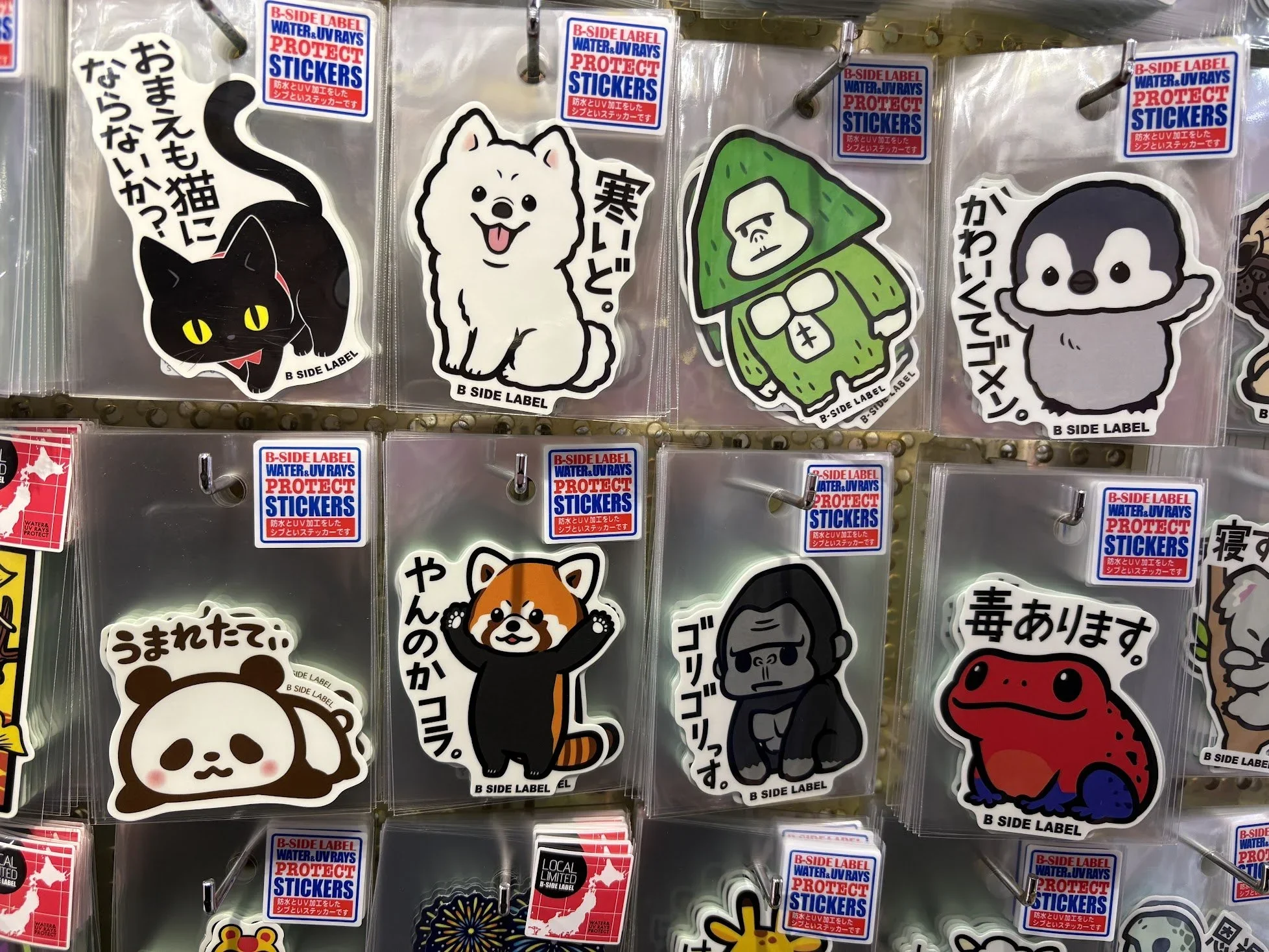 A closeup of cute Japanese animal stickers including a cat, dog, gorilla, penguin, panda, red fox, and a frog.
