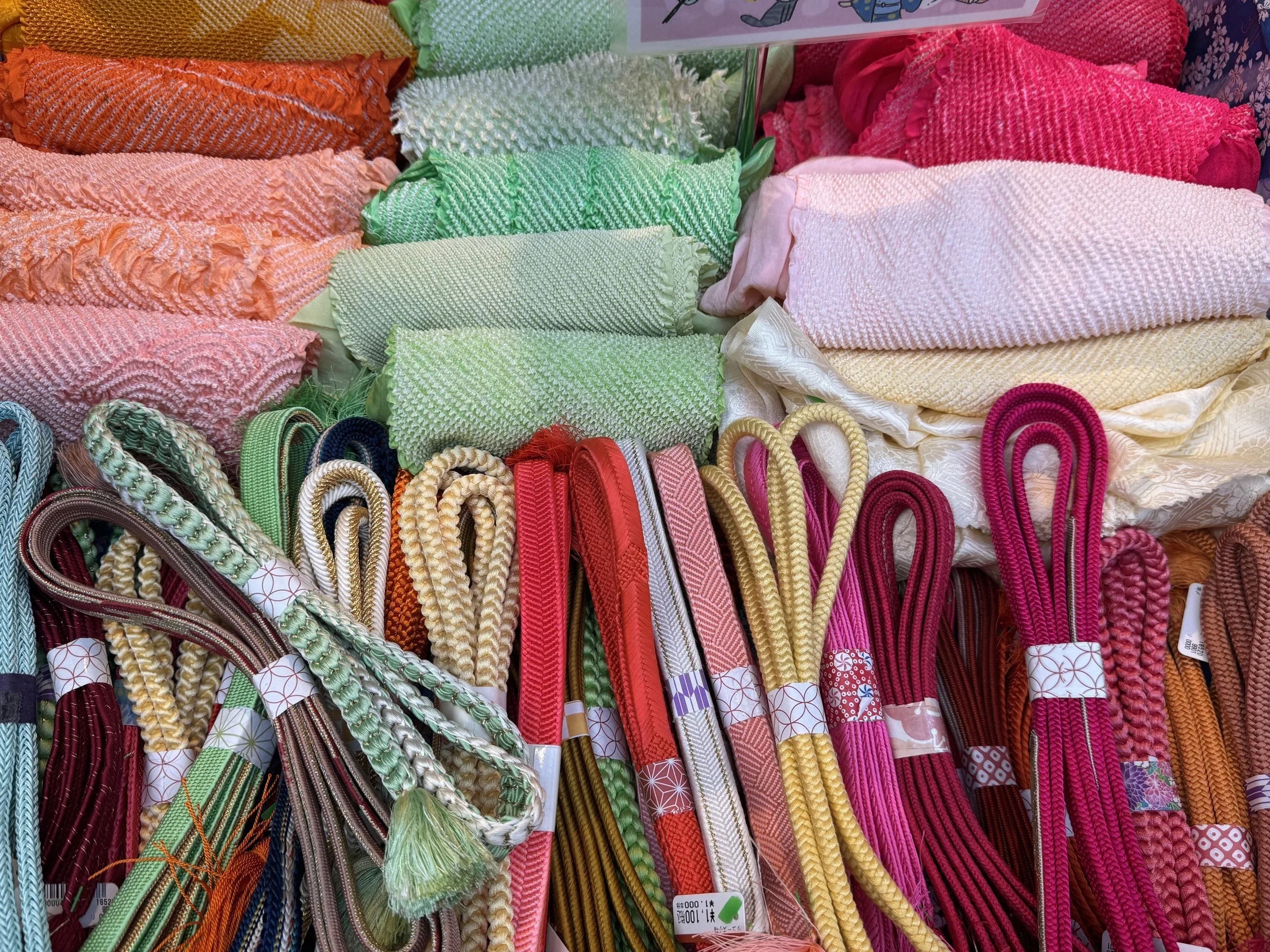Colorful red, yellow, magenta, rust colored Japanese kumihumo or braided ropes often used to hold together an obi belt while wearing a women's styled kimono.
