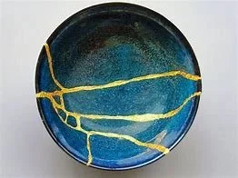 Blue ceramic plate repaired with lines of gold leaf kintsugi, the traditional Japanese art form.