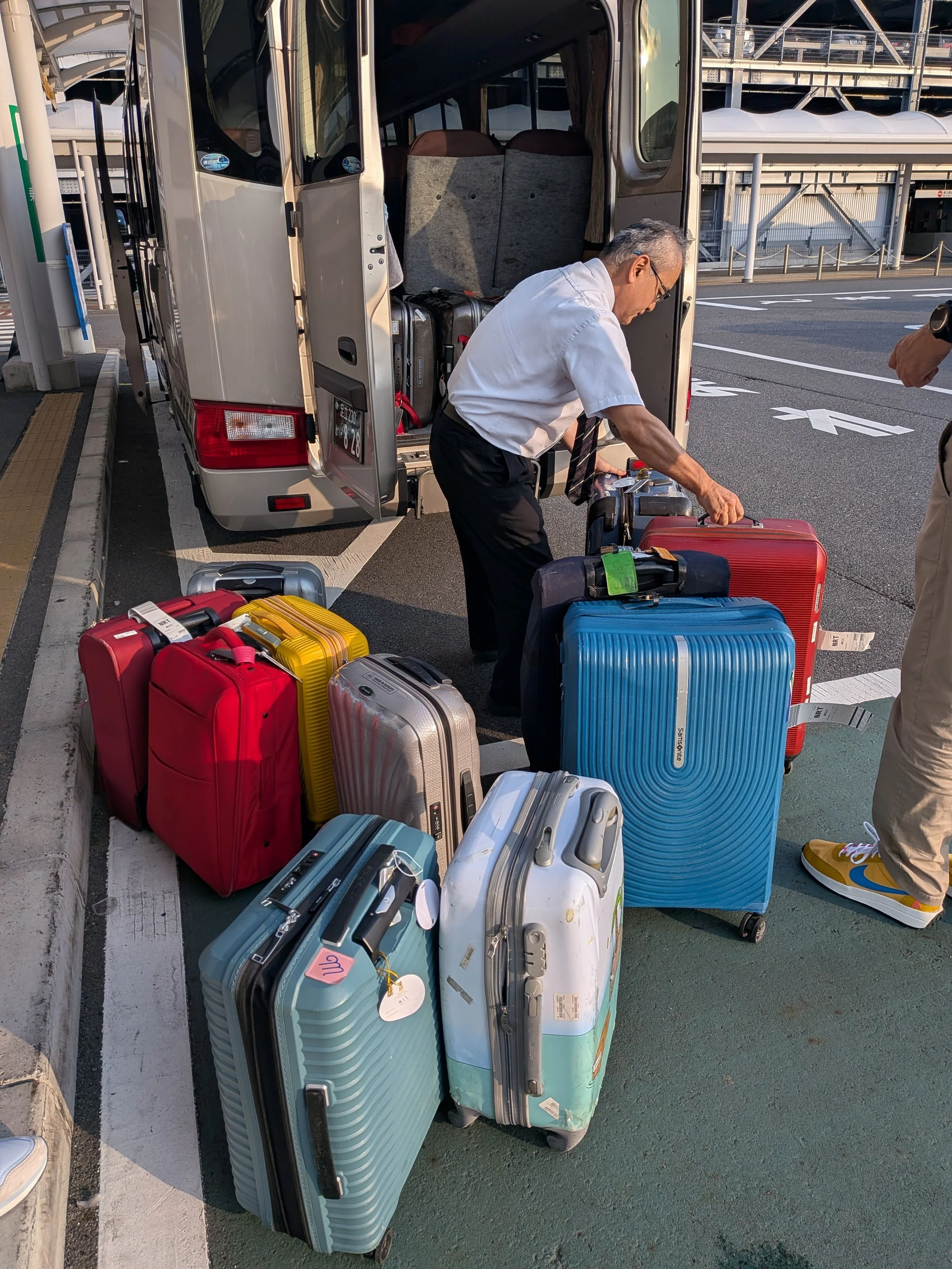 Tokudaw driver loading customer's luggage into the TokudAw van.