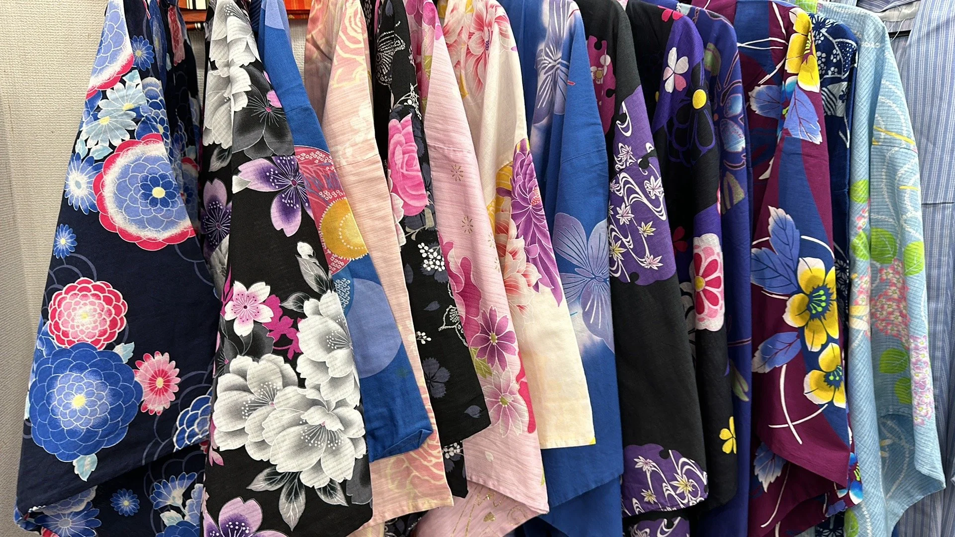 Secondhand colorful Japanese Kimono and Yukata souvenirs handing side by side at a store