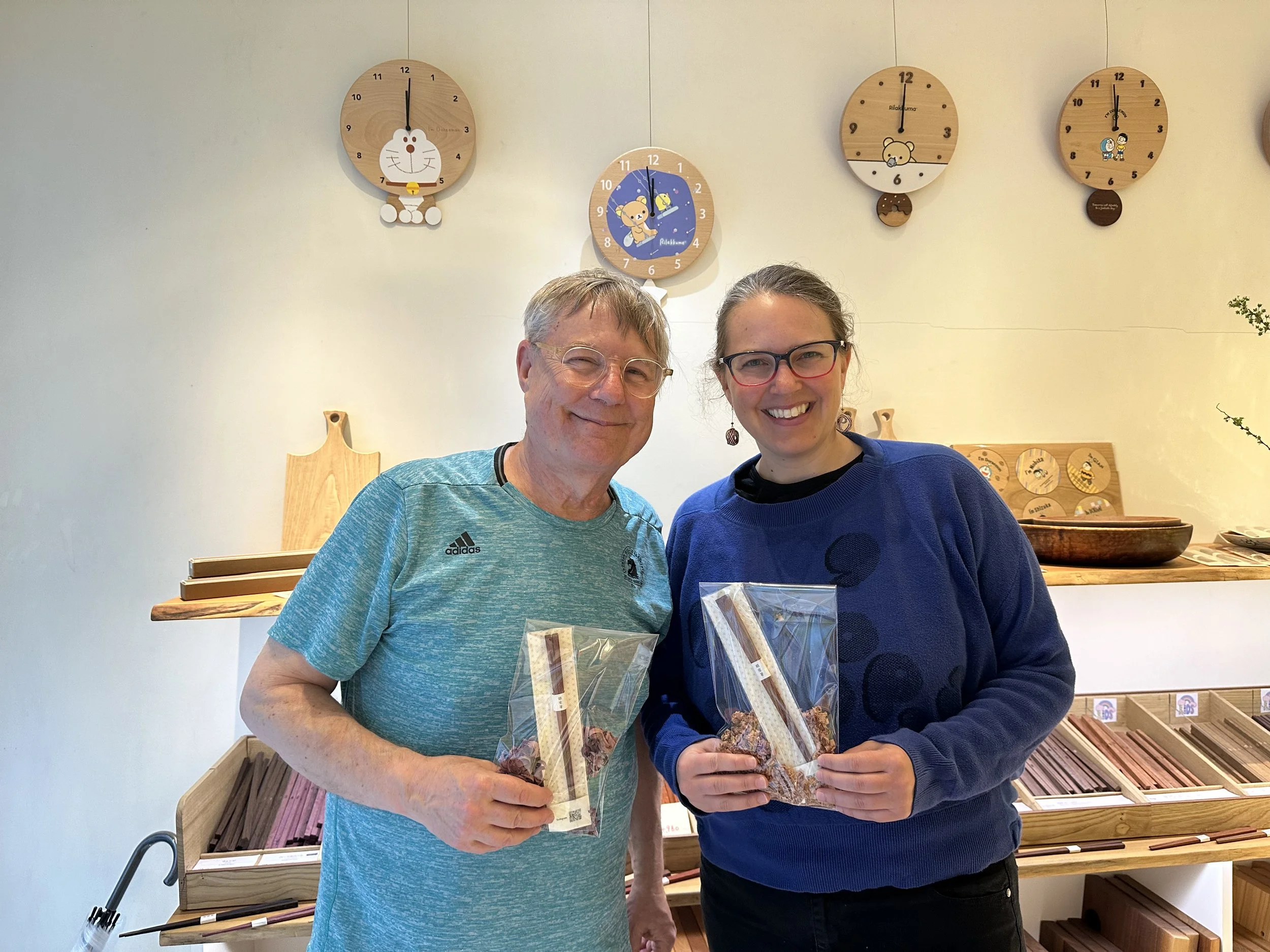 Father and daughter post with handmade chopsticks.