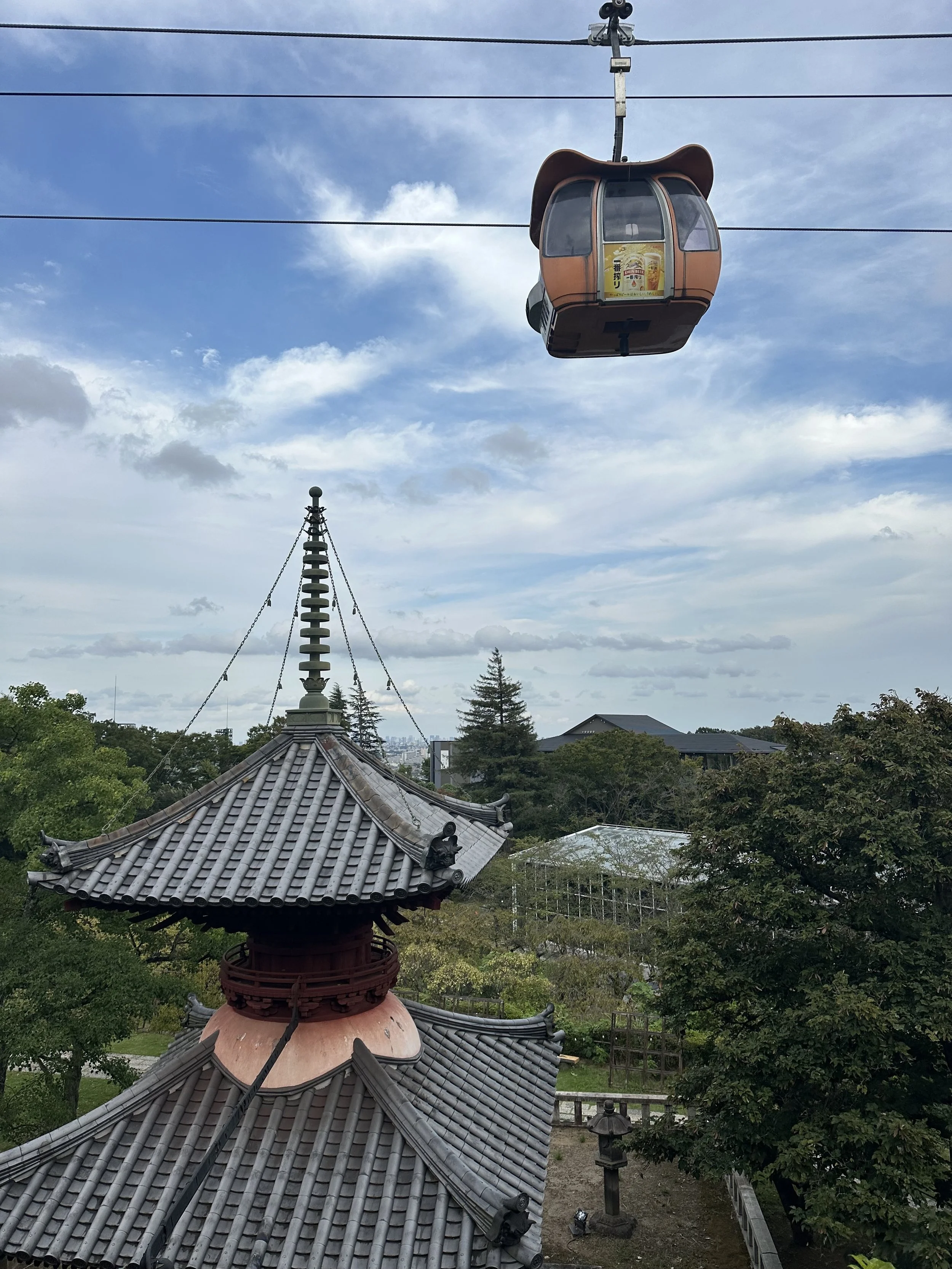 A gondola car goes past a shrine on the premise of the HANA BIYORI botanical garden in an amusement park in Japan.