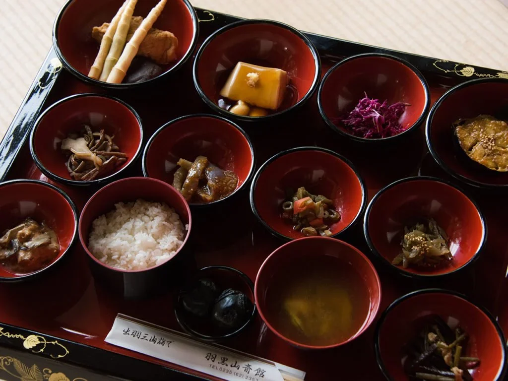 Shoshin Ryori, or traditional Japanese Buddhist Cuisine is presented on a lacquer tray with 10 mini-bowls each with a different item.