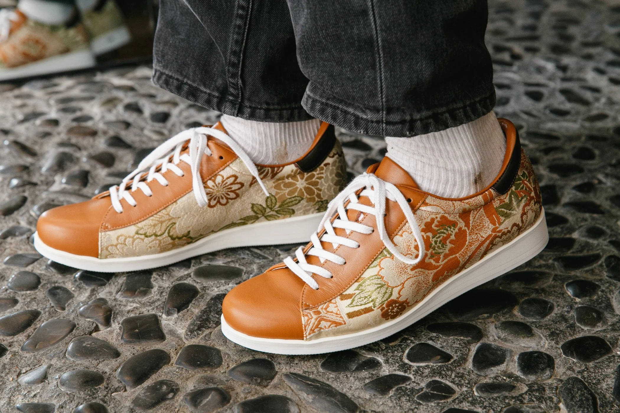 Orange tennis shoes made out of a floral kimono pattern.