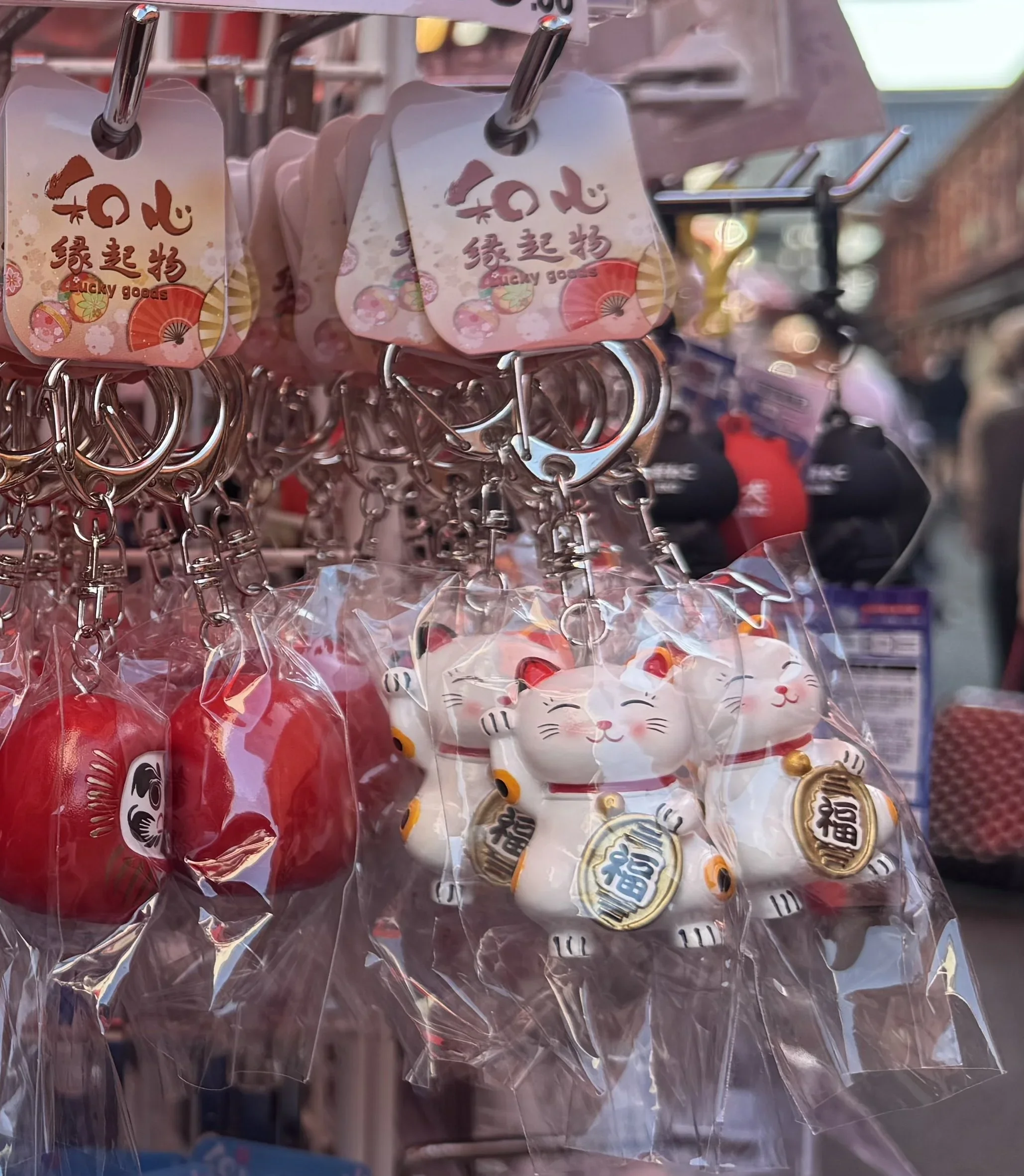 Beckoning white cat key chain with one paw.  raised