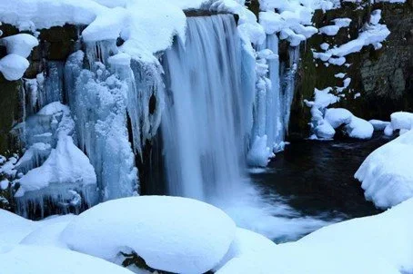 Frozen waterfall with snow covered rocks in Aomori's Oirase Gorge in northern Japan perfect for photographers.