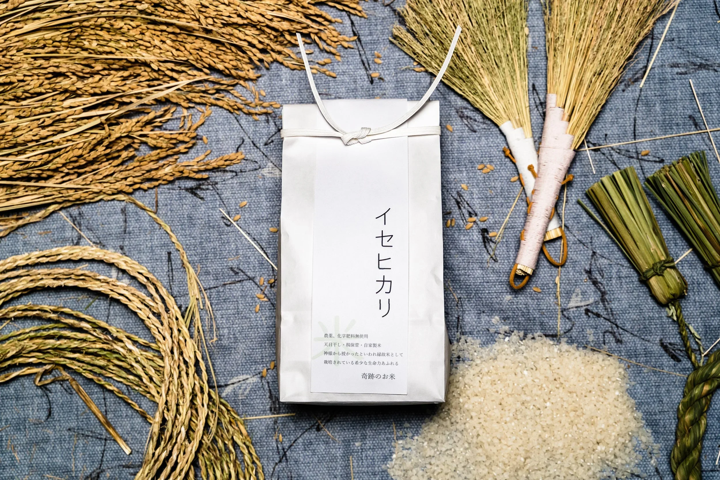 Image of white paper bag of rice and dried rice props in the background.