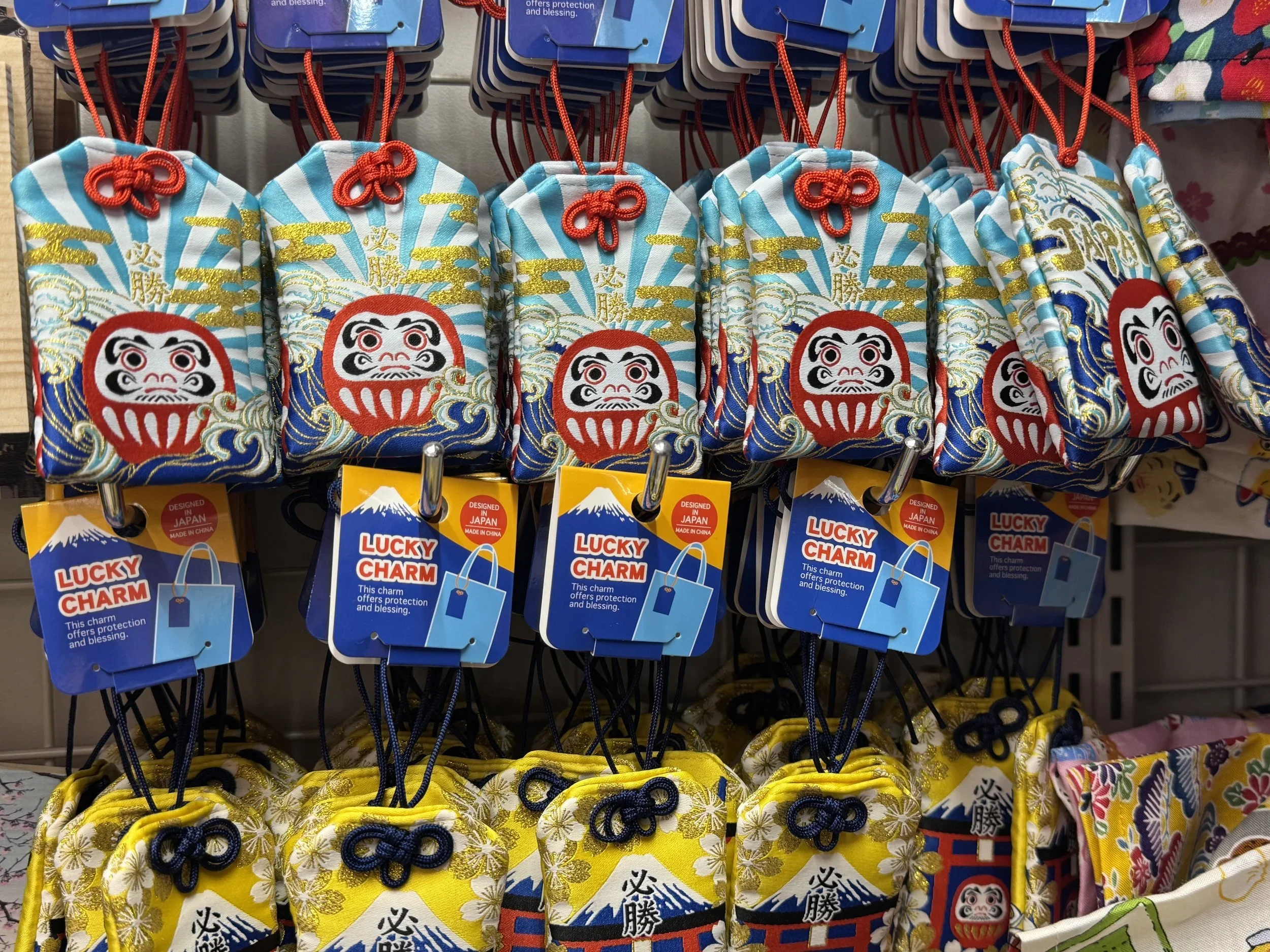 A good luck charm known as an Omamori with a daruma doll and the great wave motif.