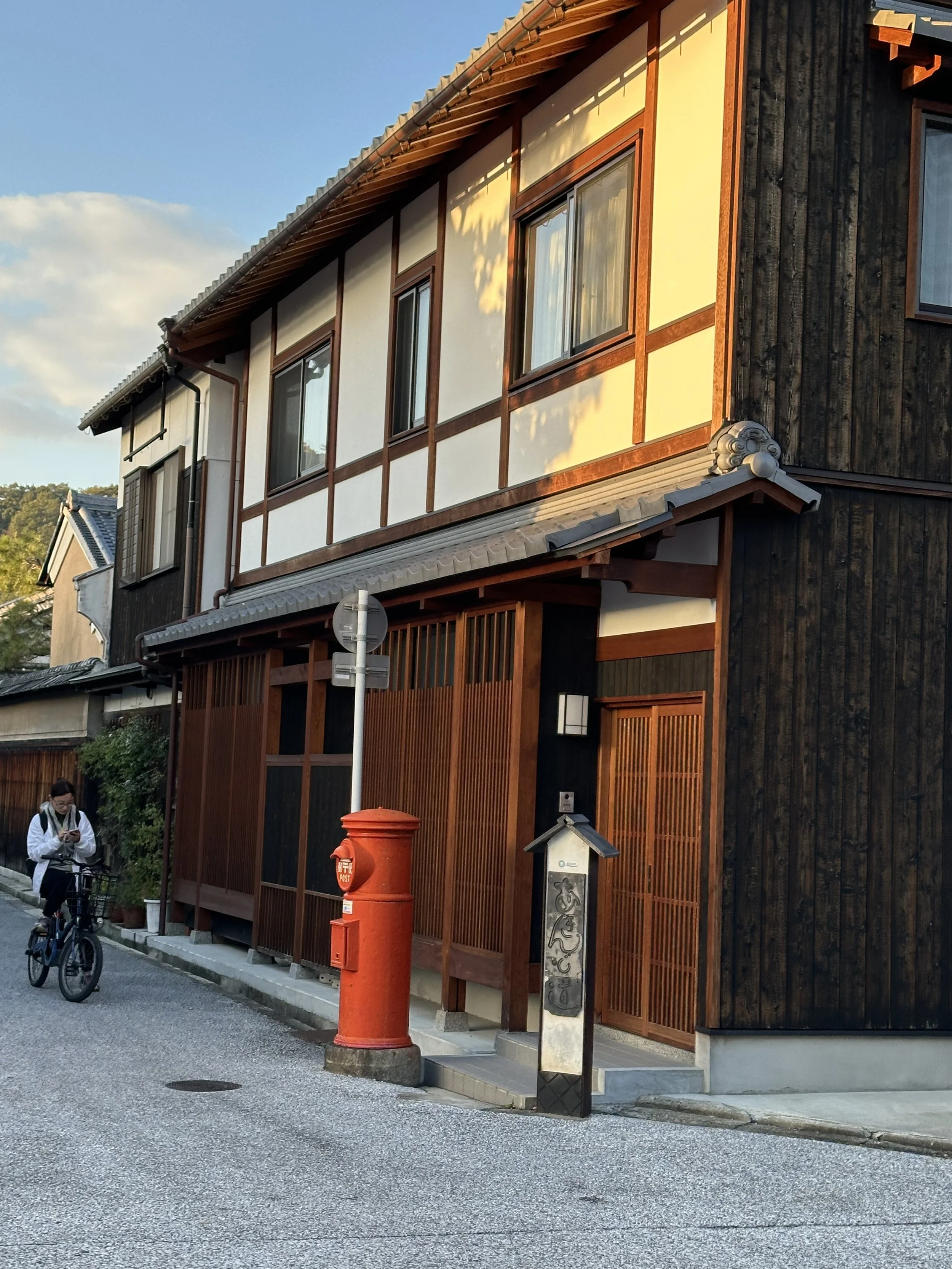 Street with multiple house of old Japanese architecture with wooden panels and tiled roof at golden hour showcasing japanese craftsmanship