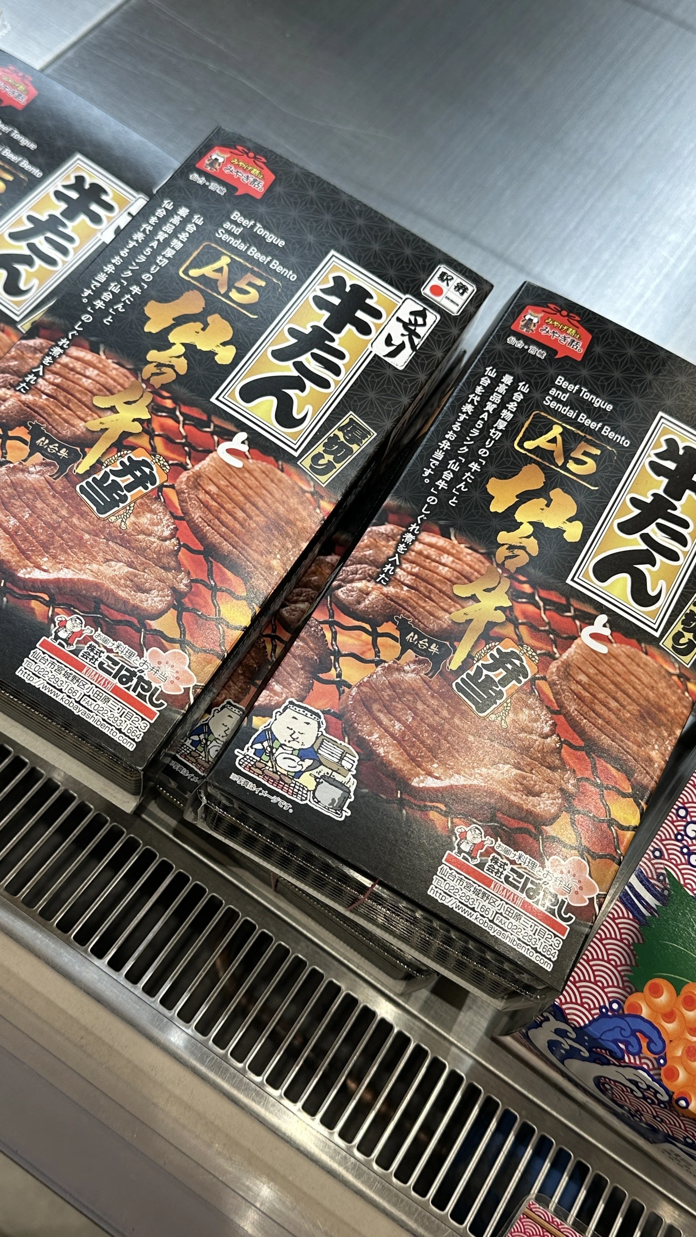 Two meat bento boxes on a shelf in Tokyo Station.