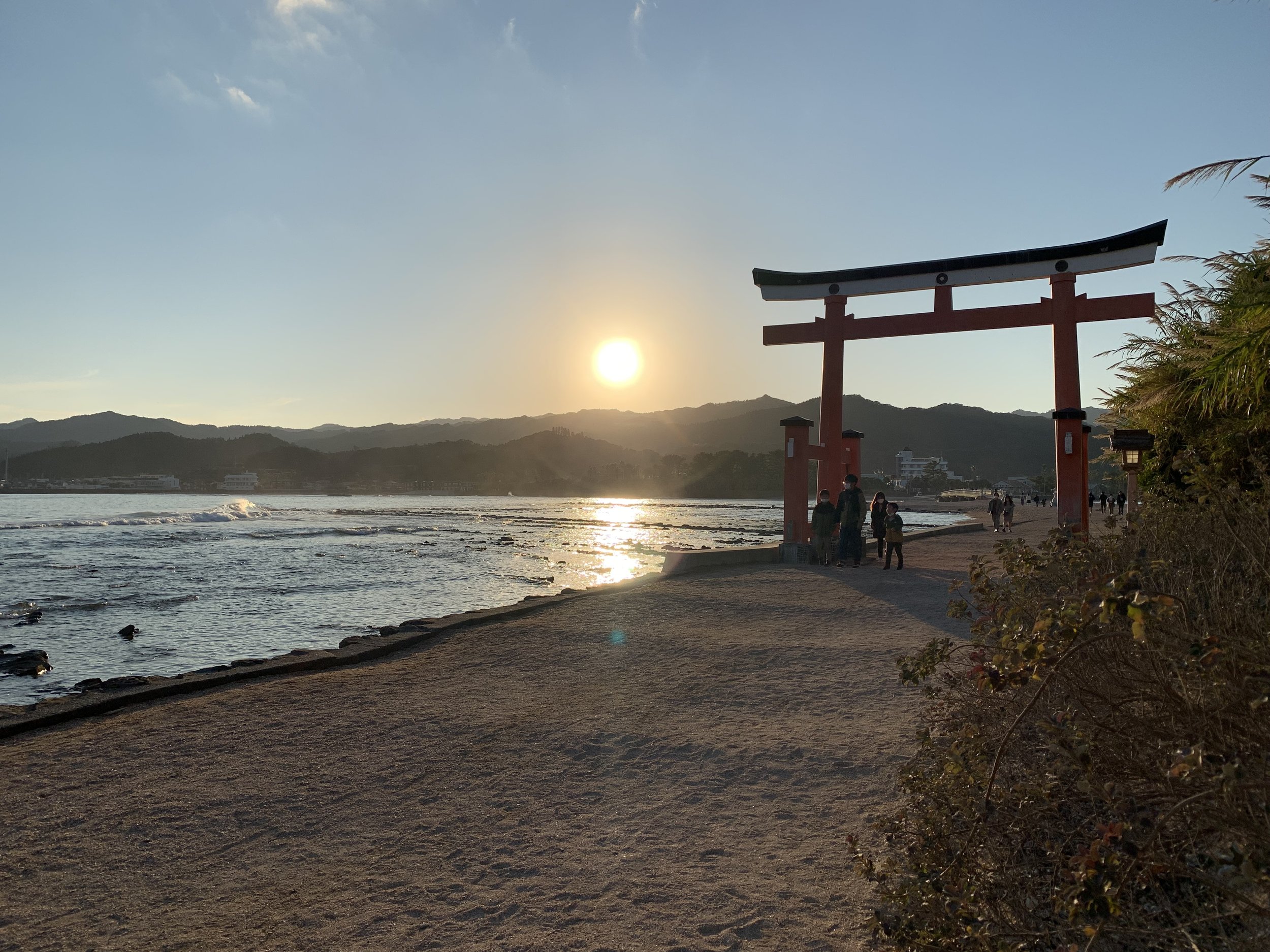 A scene of a tori gate on the beach at sunset in Miyazaki, Japan.