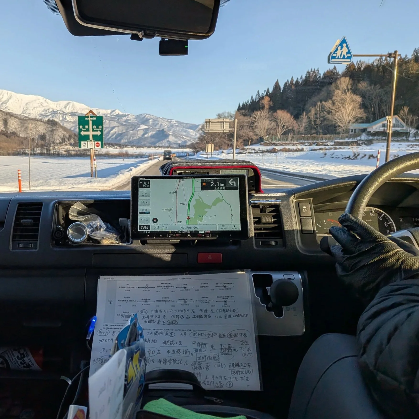 Driver dashboard featuring the drivers hands on the wheel and navigation.