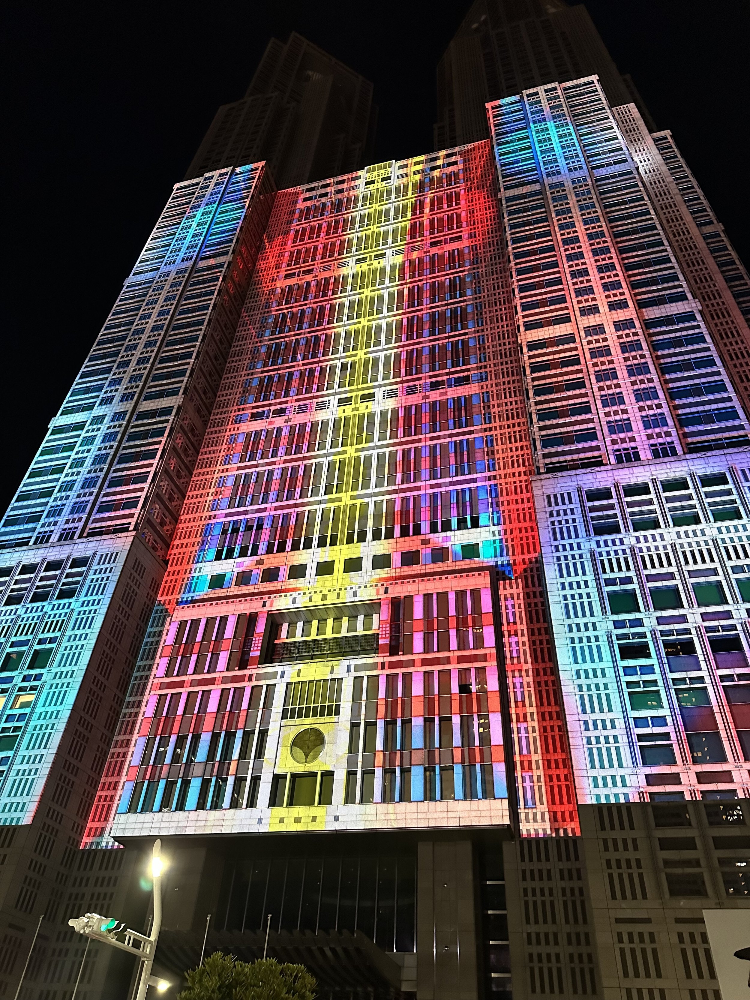 Colorful projection mapping display at night of yellow red and blue lights on the Tokyo Metropolitan building in Shinjuku, Tokyo.