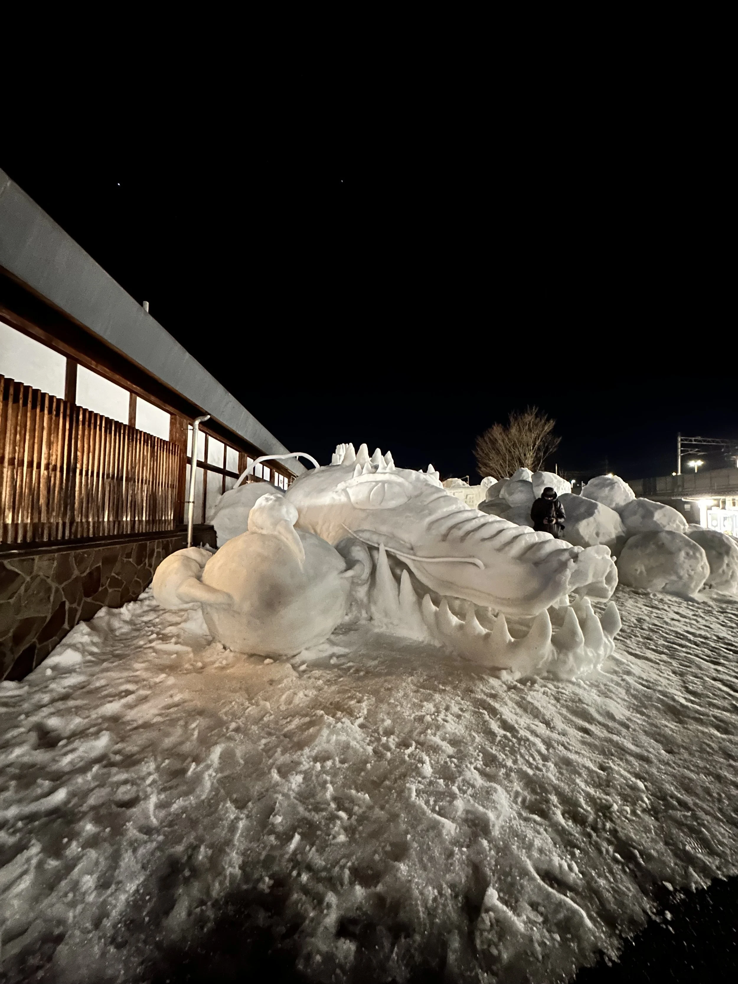 Dragon sculpture in Snow festival in Tokamachi, Niigata Japan next to old wooden Japanese architecture.