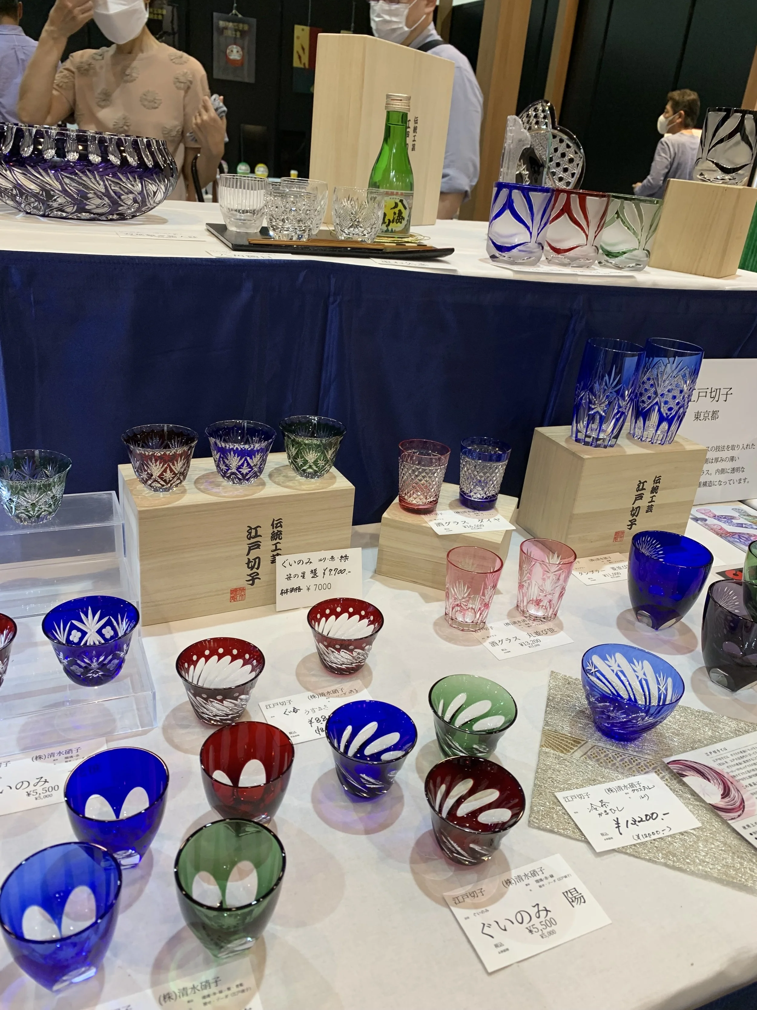 Display of colorful Edo Kiriko or etched glassware and wooden protective boxes.