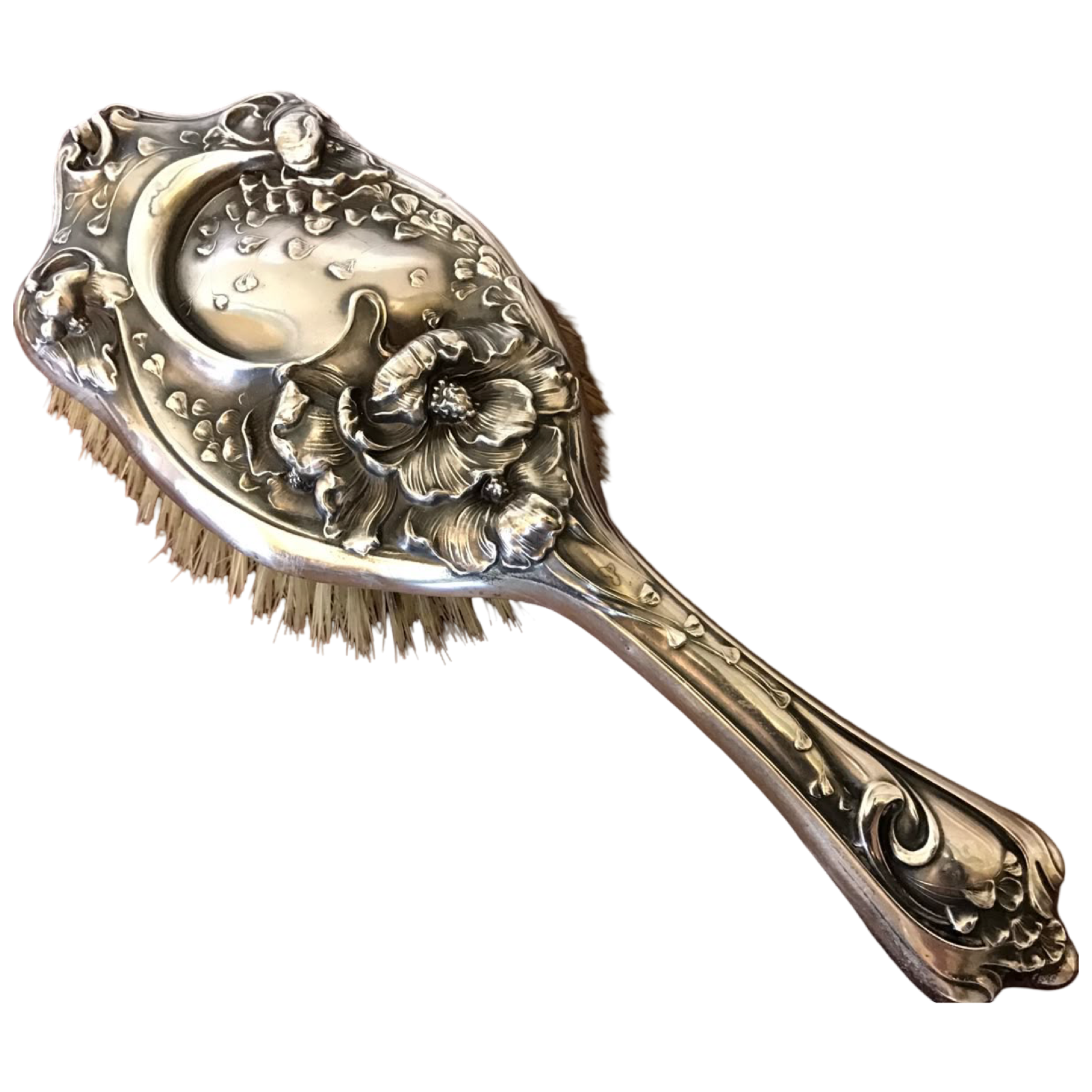 An ornate silver hairbrush with floral and decorative designs, featuring a detailed handle and decorative motifs on the brush head.