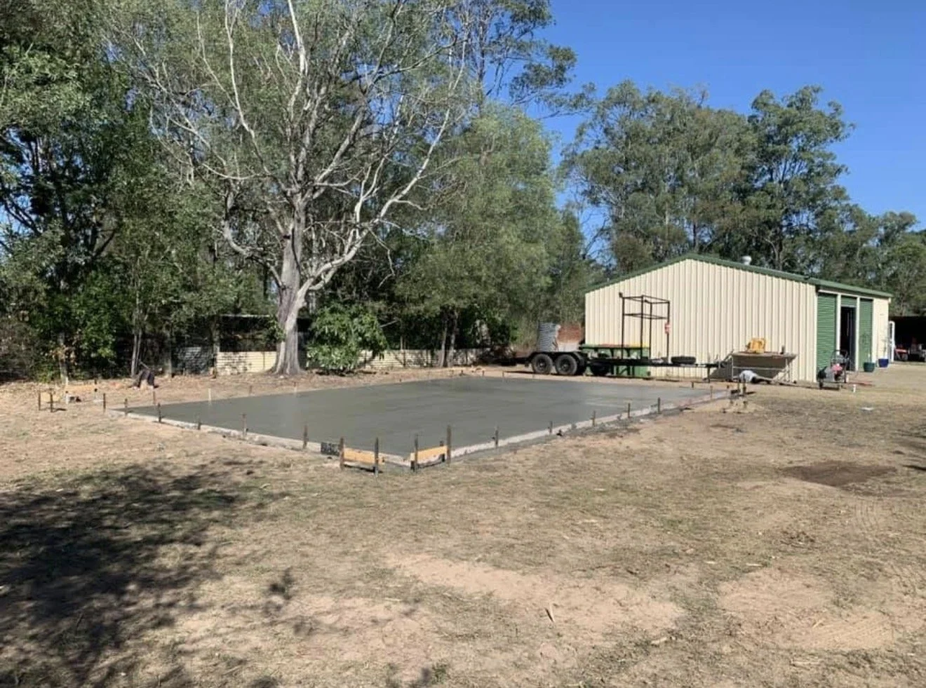 Freshly poured concrete slab for backyard shed foundation