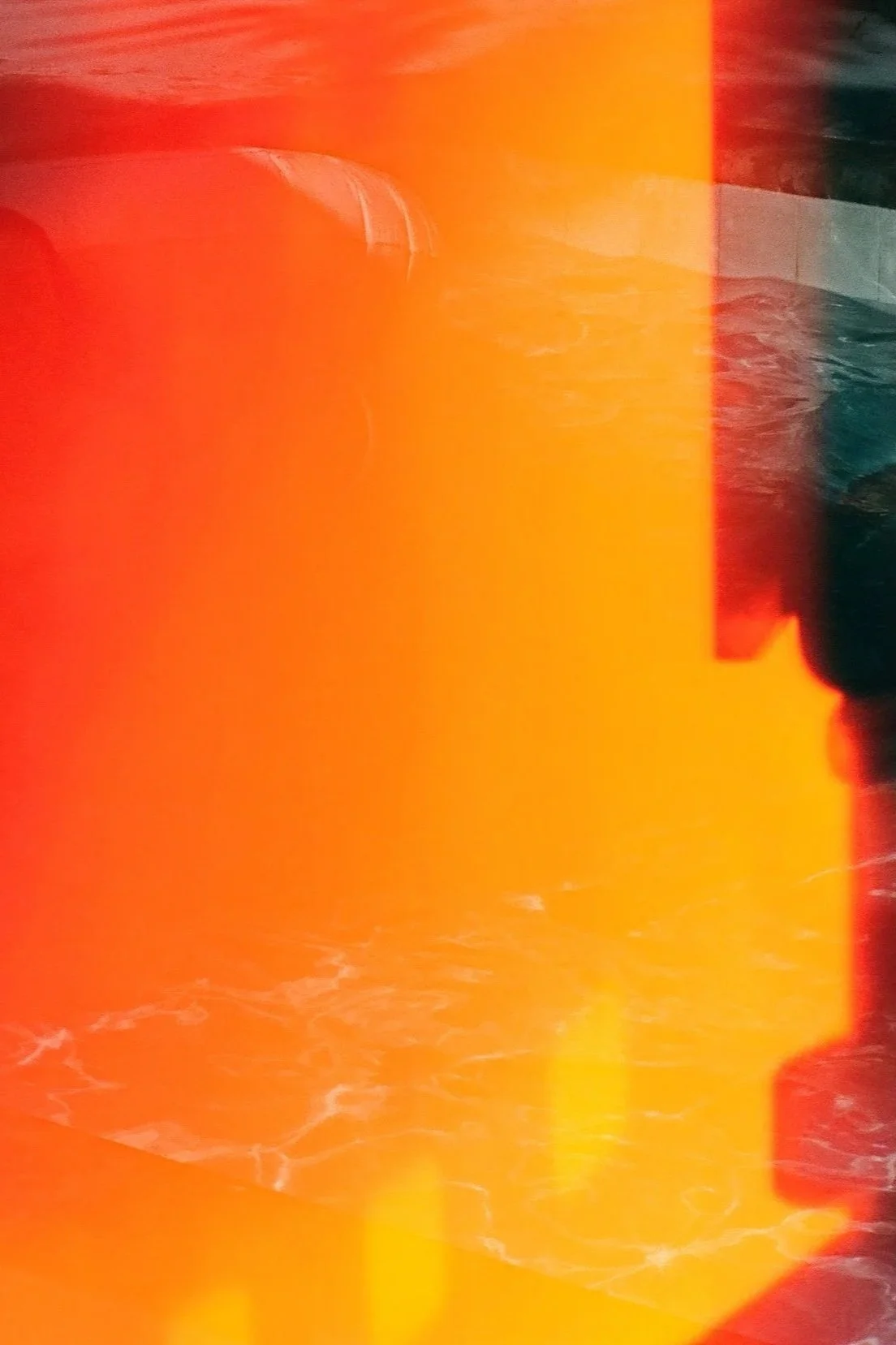 Abstract image with vibrant orange and yellow hues, with some darker and lighter areas, and a swirl of white lines at the bottom.
