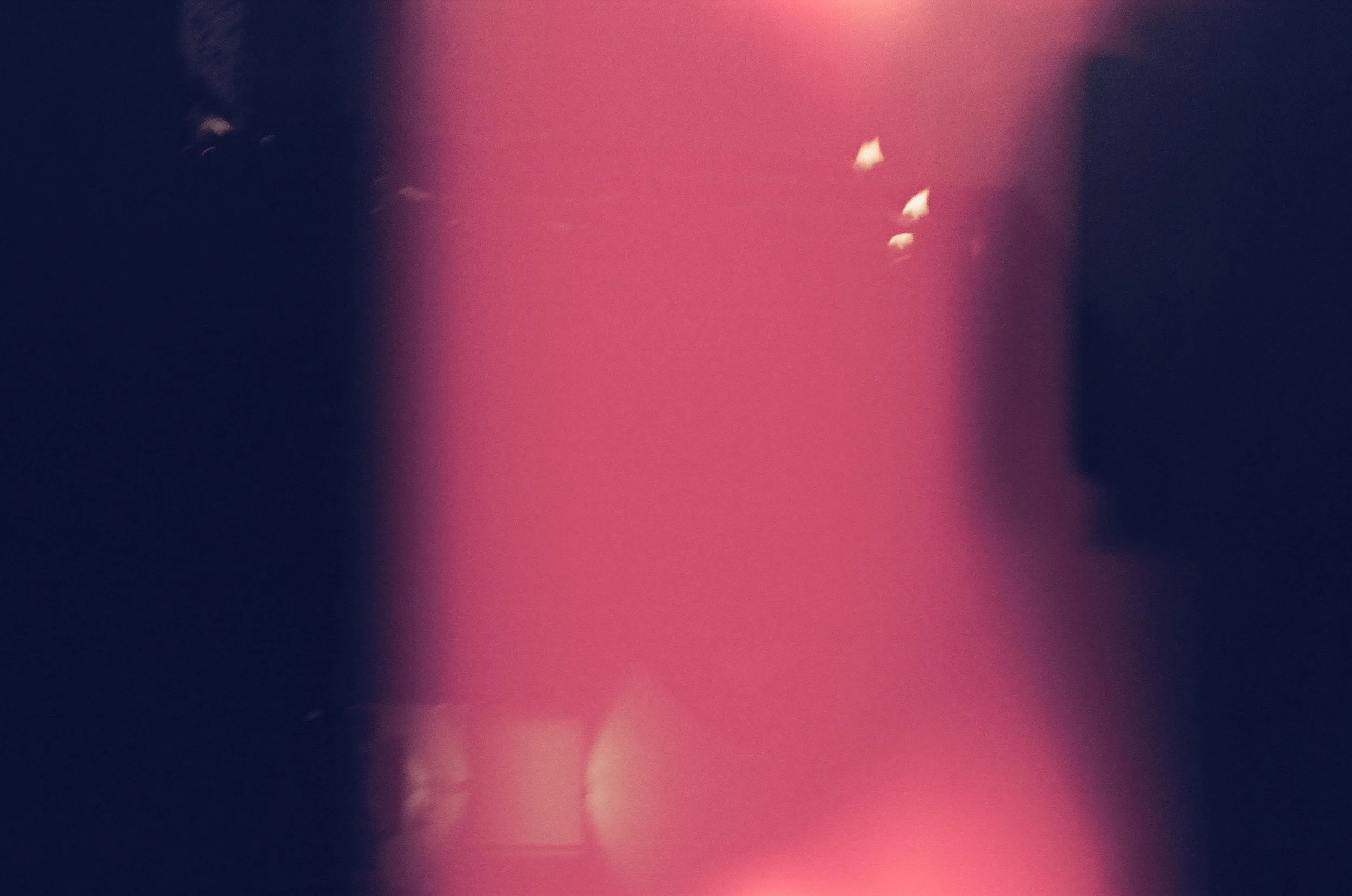 Abstract image with a pinkish hue, blurred shapes, and no distinct objects.