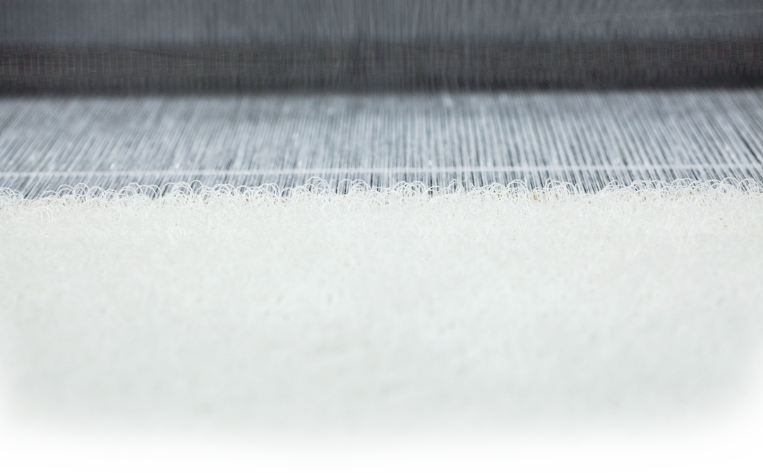 UCHINO towels yarn making. Close-up of layered fabric or textile materials with different textures and colors.