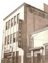UCHINO 1947 building. World-Class Towel Maker. Black and white photo of a multi-story building with Japanese signage.