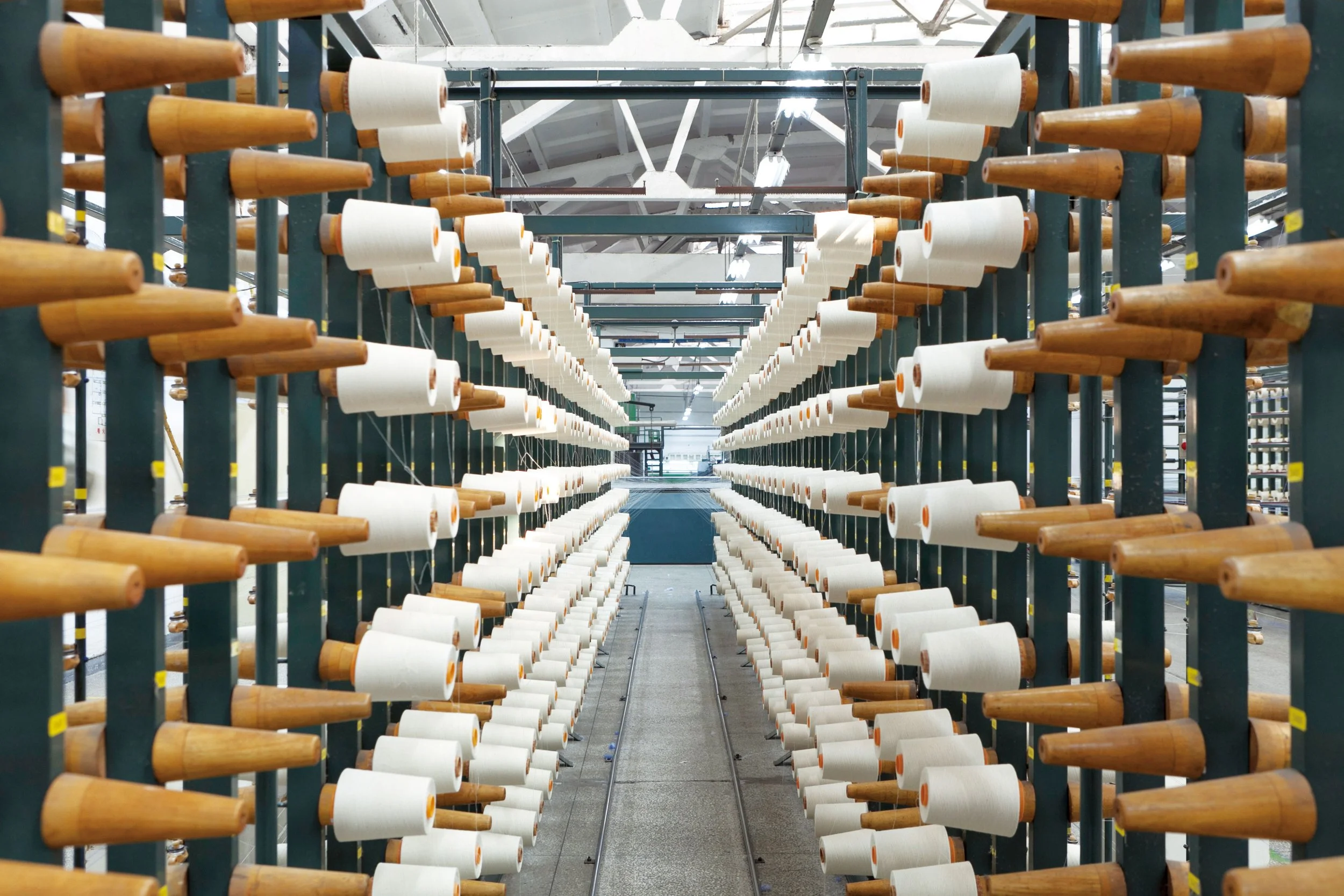 UCHINO Towels Factory. Rows of empty textile spools or bobbins in a factory or warehouse setting.