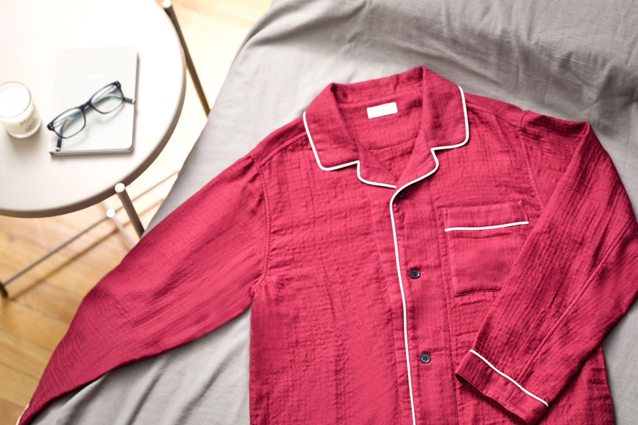 Red-colored UCHINO Marshmallow Gauze Pajama. A red pajama top with white piping on a gray surface.
