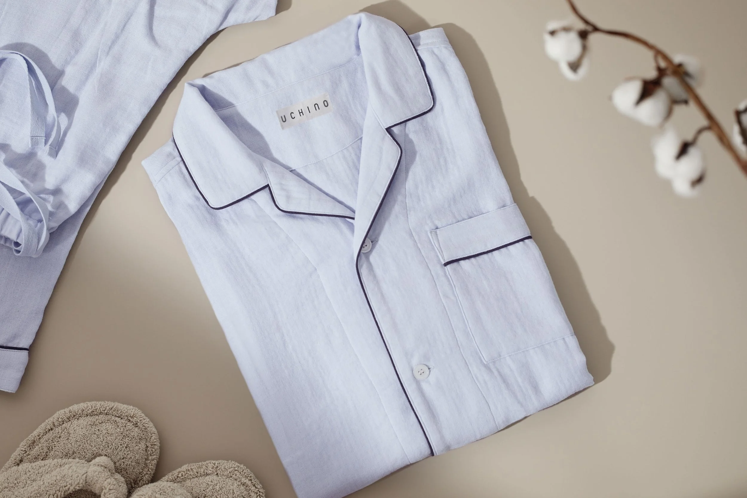 Light blue-colored UCHINO Marshmallow Gauze Pajama. A neatly folded set of light blue pajamas with dark piping.