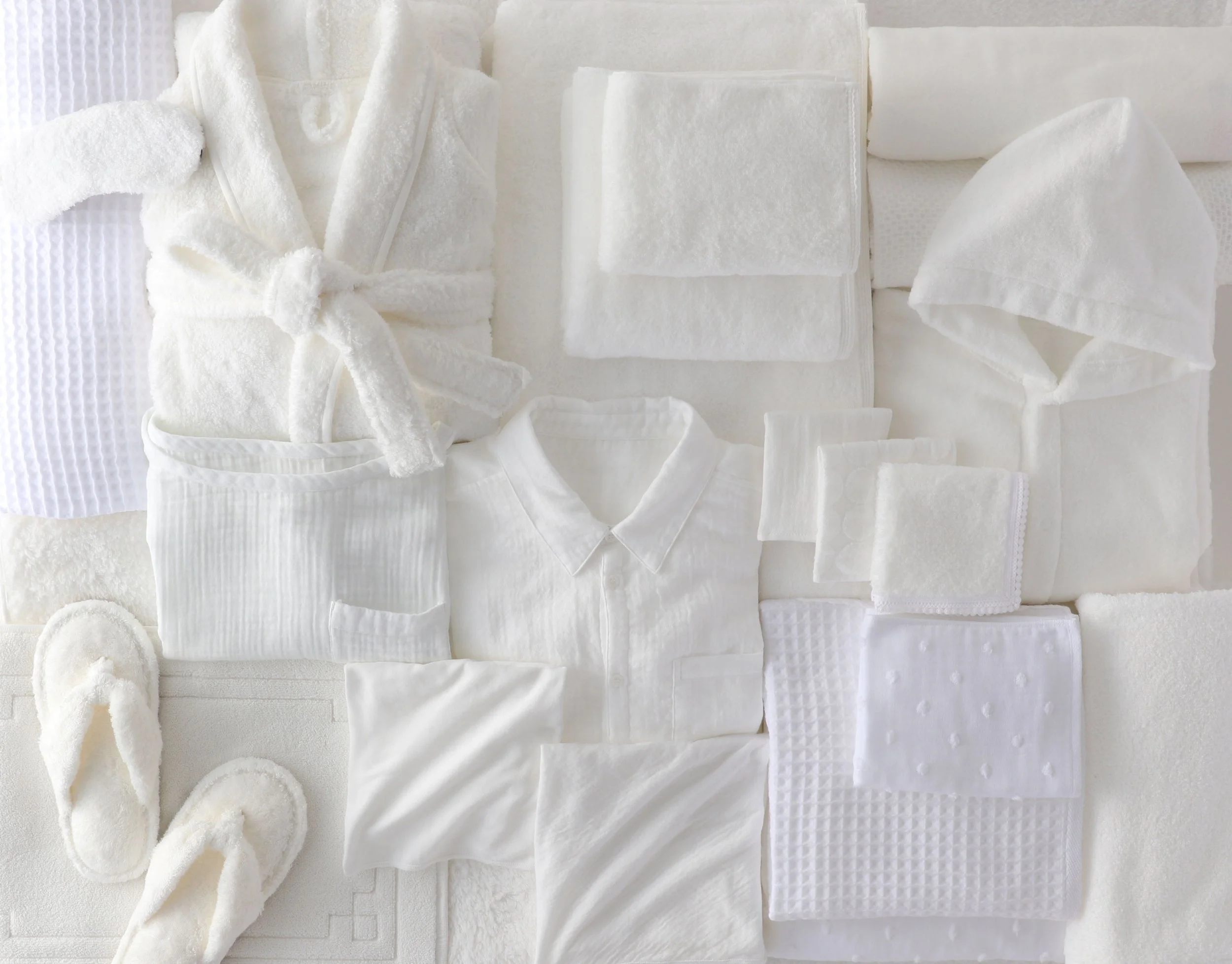 A collection of white UCHINO towels. Bathrobes, Sandals, Towels.