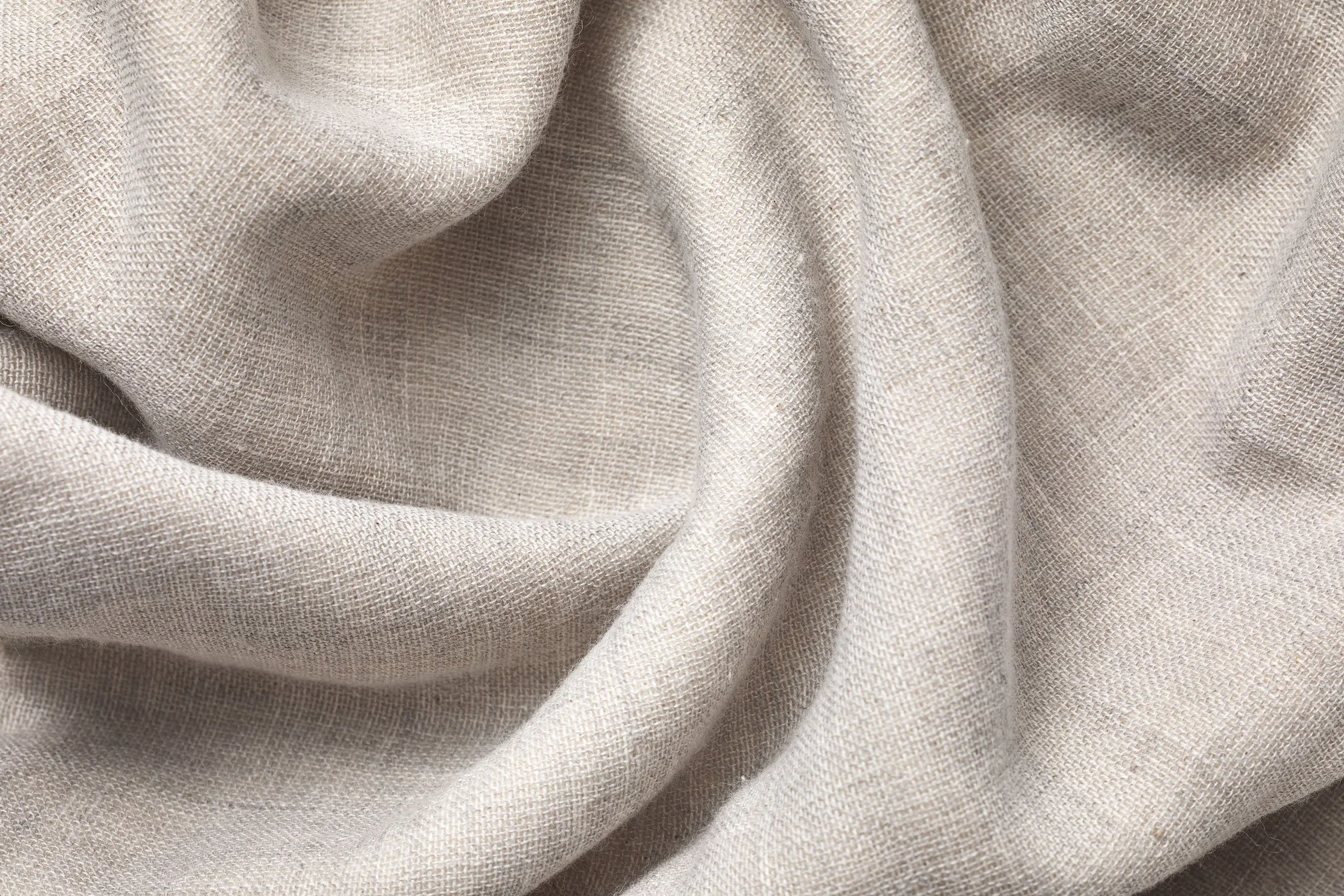 UCHINO fabric Close-up view. Beige fabric with a textured weave, draped with soft folds.