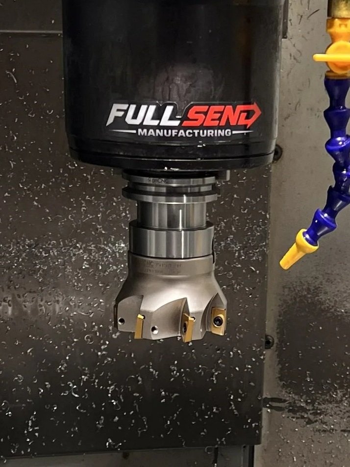 A CNC machine holding a large, specialized cutting tool with multiple inserts, used for machining metal parts.