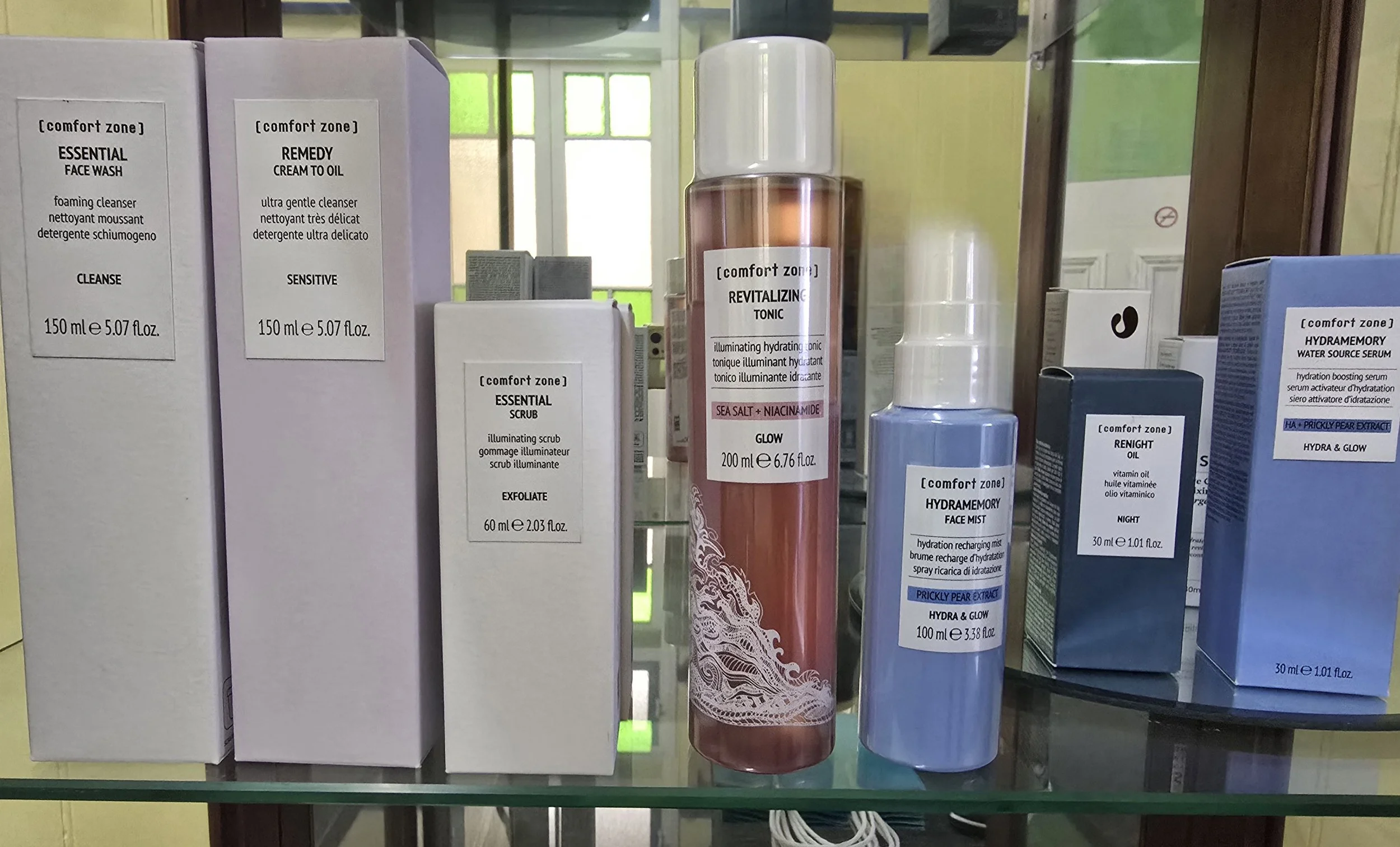 Various skincare products including face wash, cream, toner, and serum on store shelf. Mostly white and pink bottles and boxes with product labels.