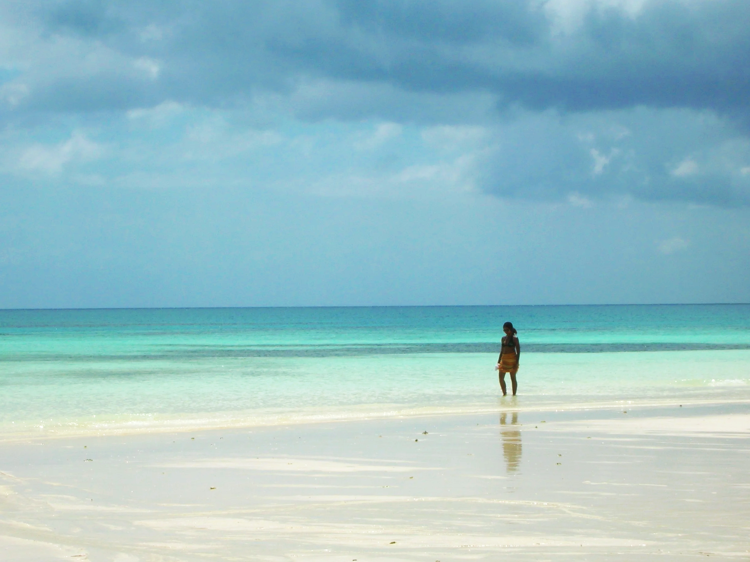 A calm beach walk in the shallows of Zanzibar Island