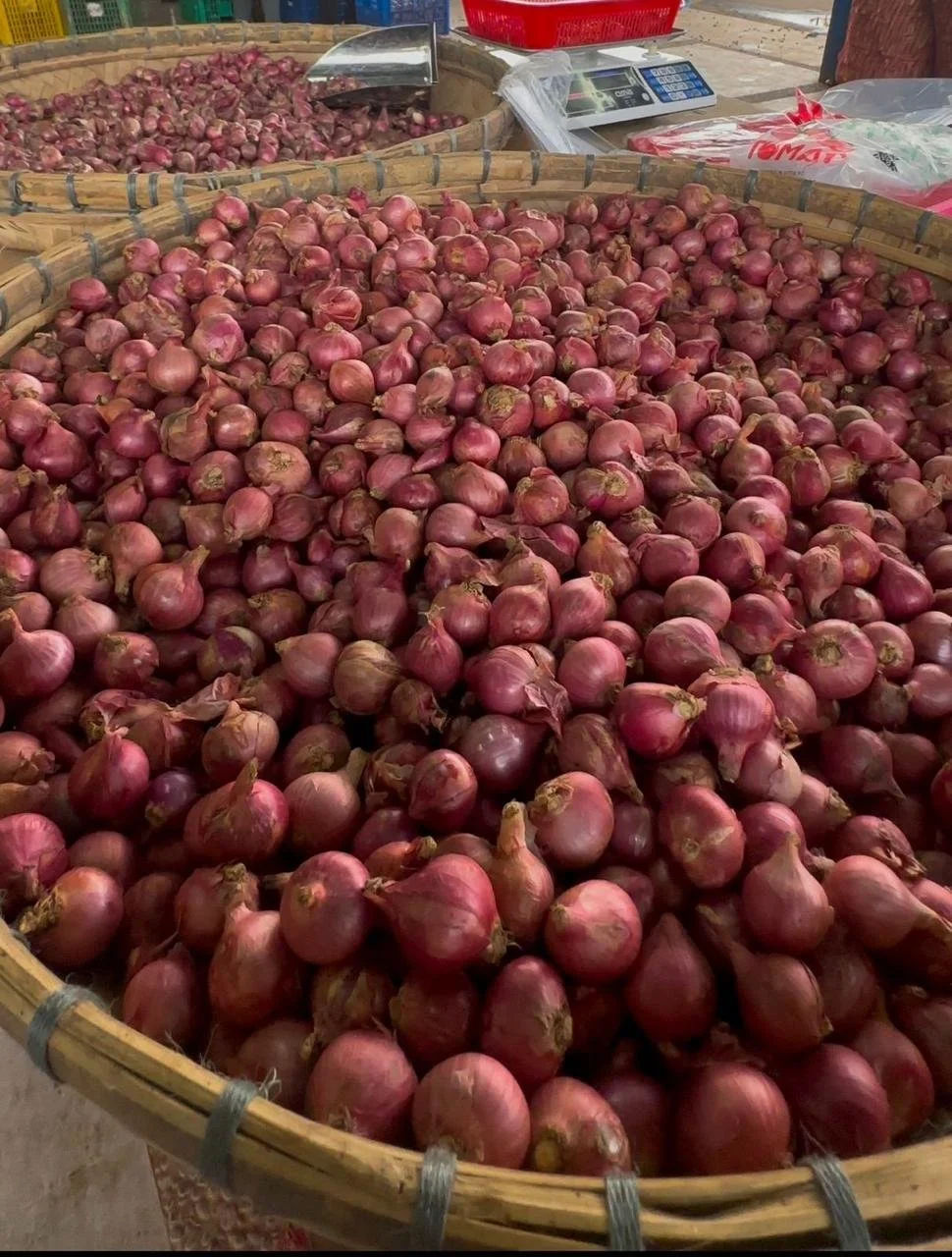 Large baskets filled with red onions at a farmhouse