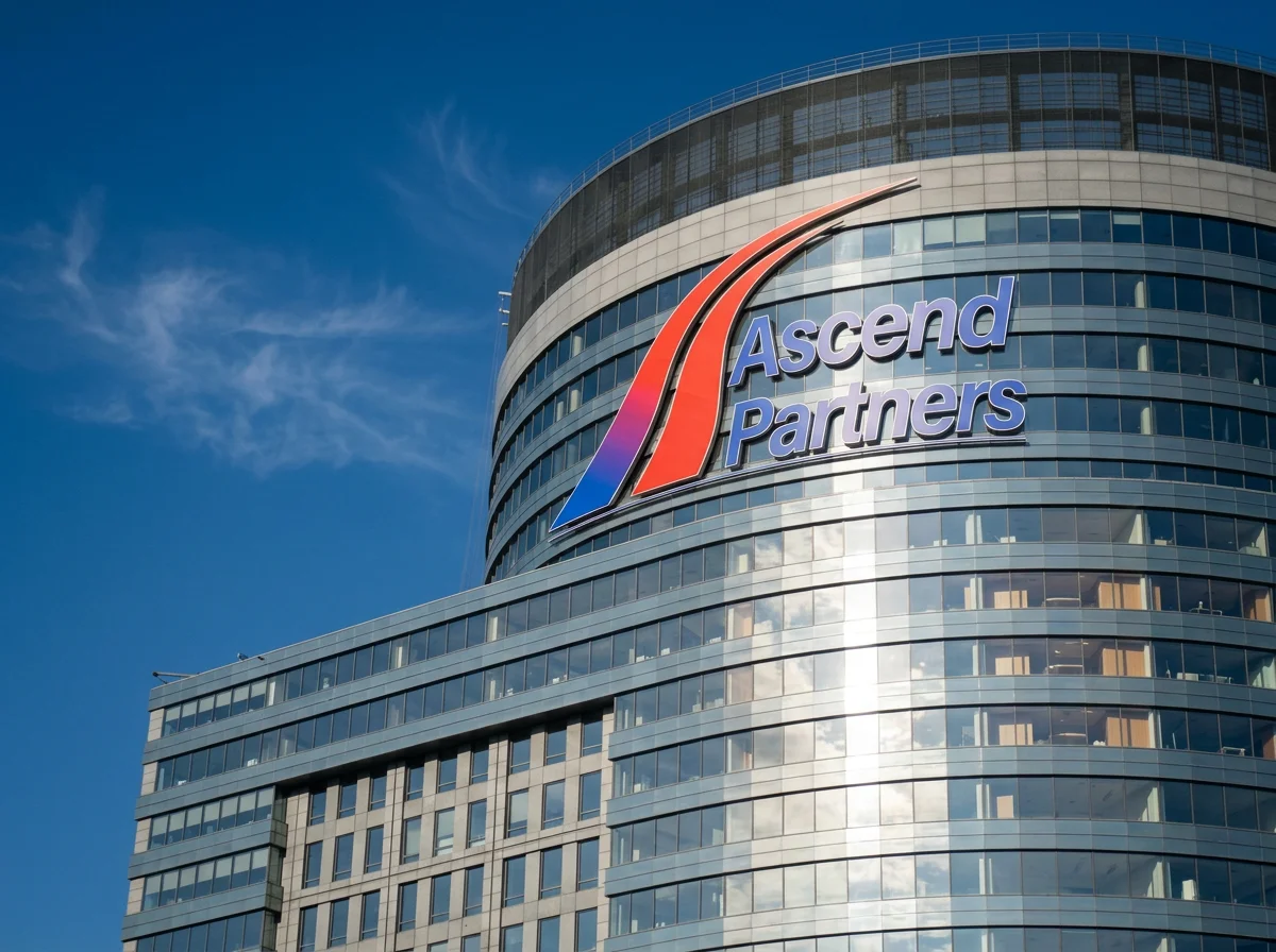 A modern office building with a large logo for Ascend Partners on its curved glass facade. The logo features colorful swooshes and text, with a blue sky and some clouds in the background.