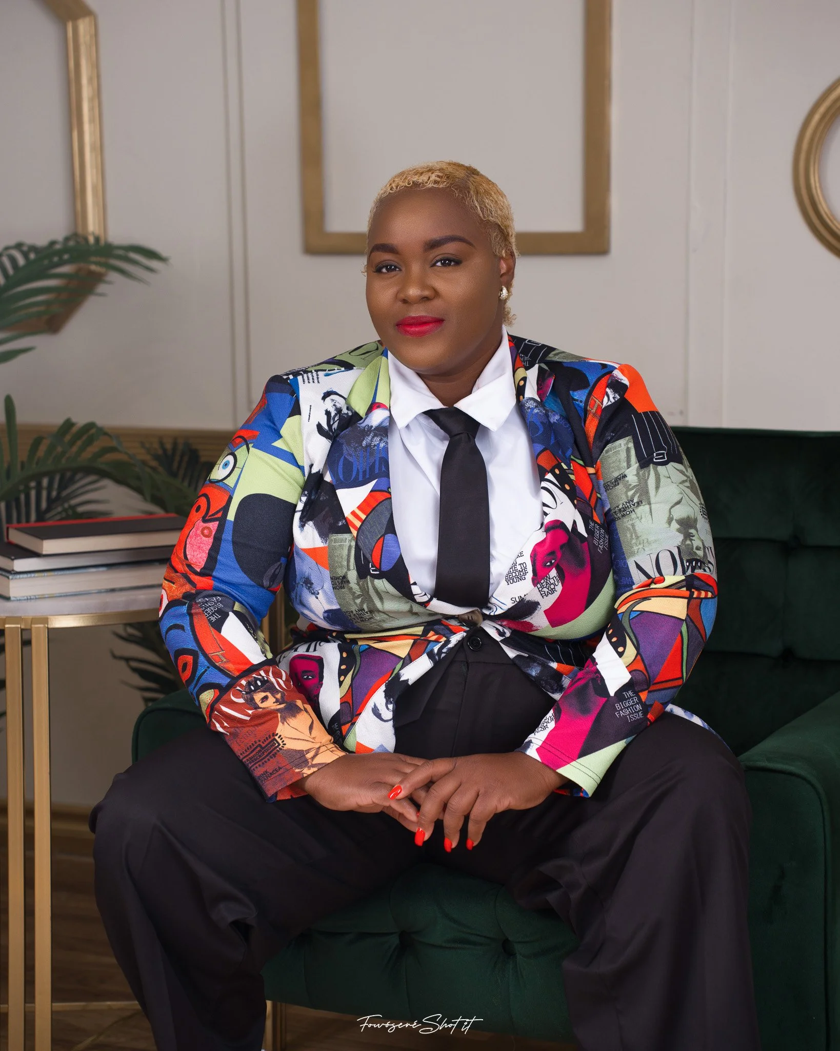 Shemeka Joseph seated in a colourful blazer in a warmly styled interior