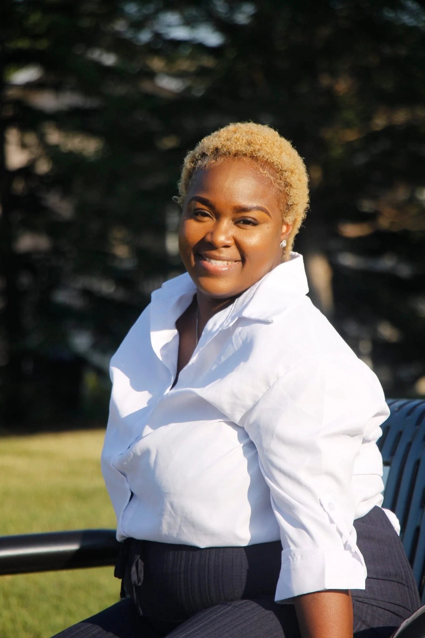 Shemeka Joseph smiling outdoors in a white blouse