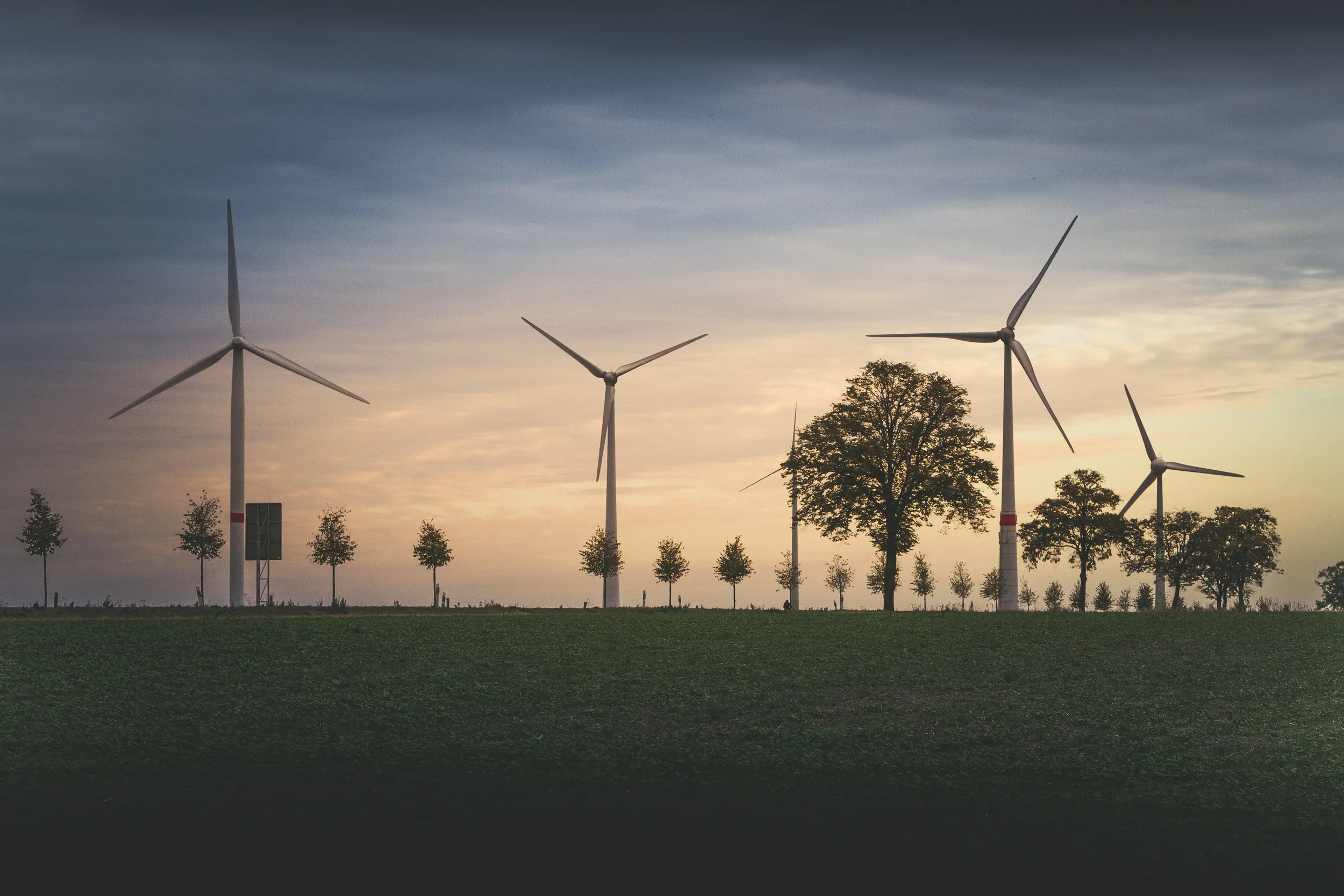 Solar and wind generation site where a flywheel smooths output and delivers synthetic inertia to meet grid codes