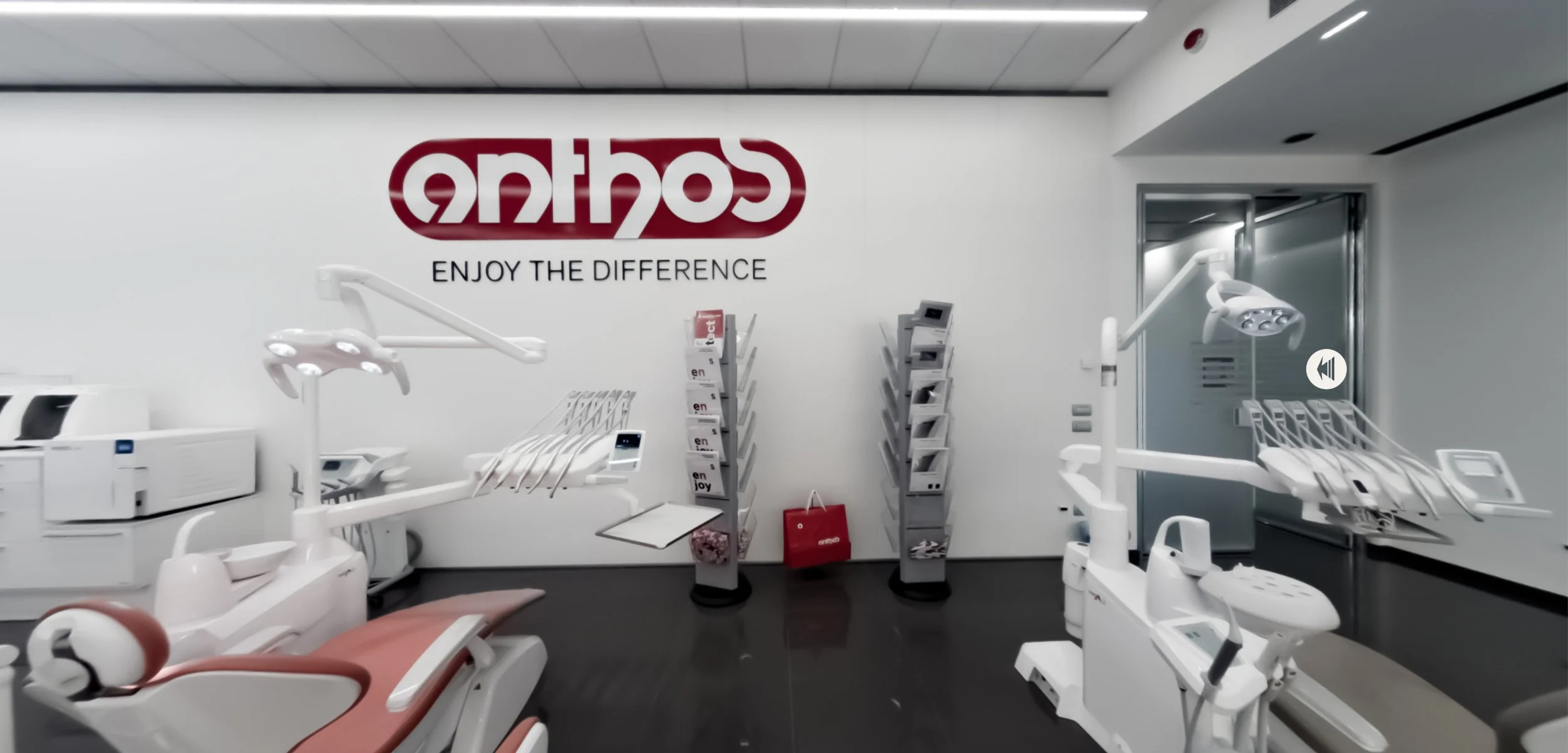 Dental clinic interior with dental chairs, equipment, and supplies, featuring a large sign on the wall that reads 'enjoy the difference'.