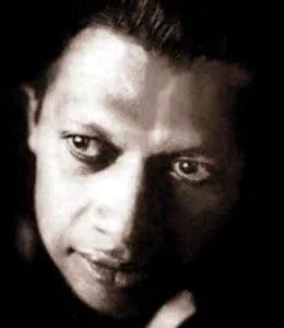 Black and white close-up of a person's face with intense eyes and dark hair.