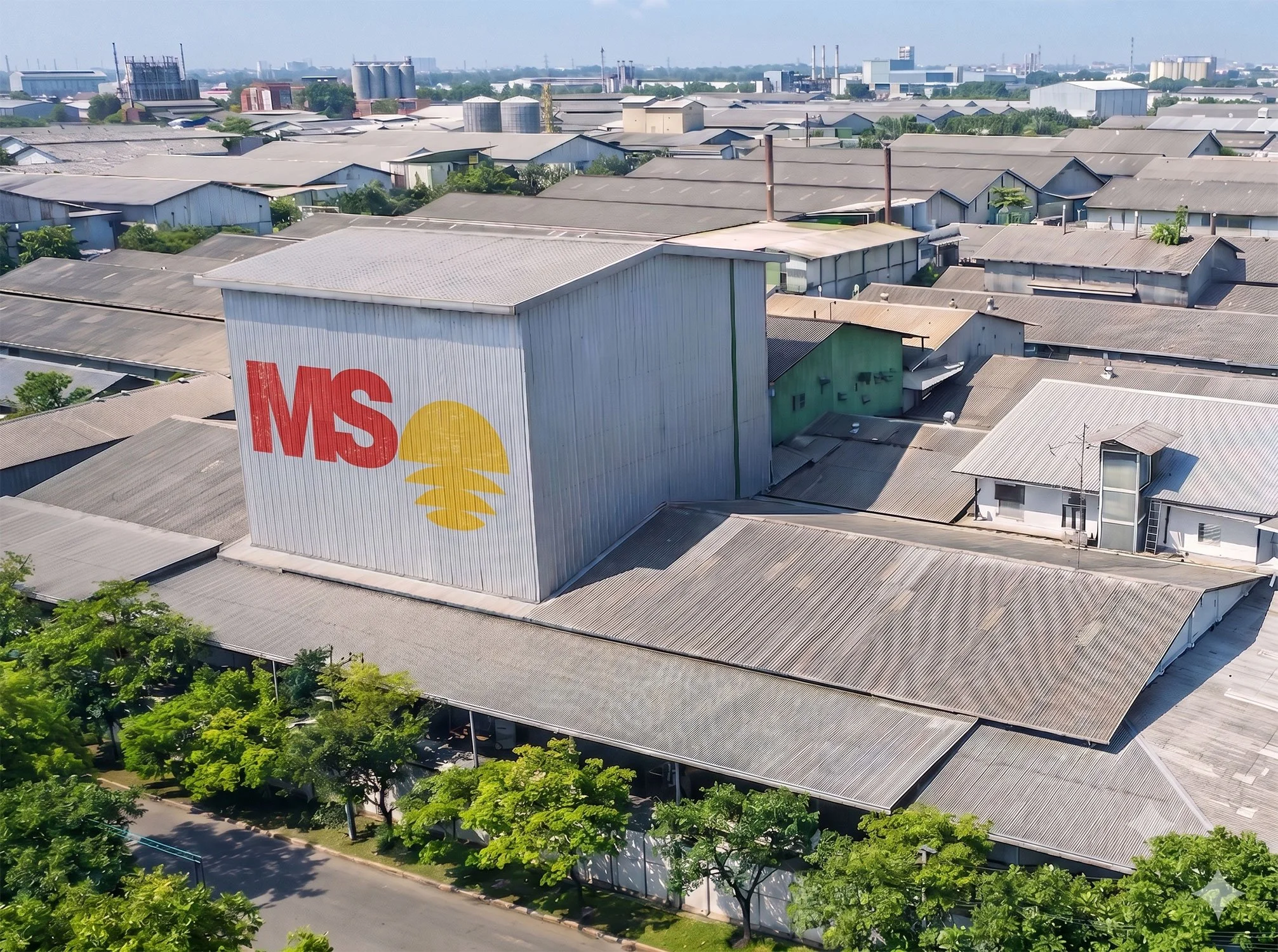 An aerial view of the Matahari Sakti industrial factory compound showing the large corporate MS rising sun logo painted on the main building facade