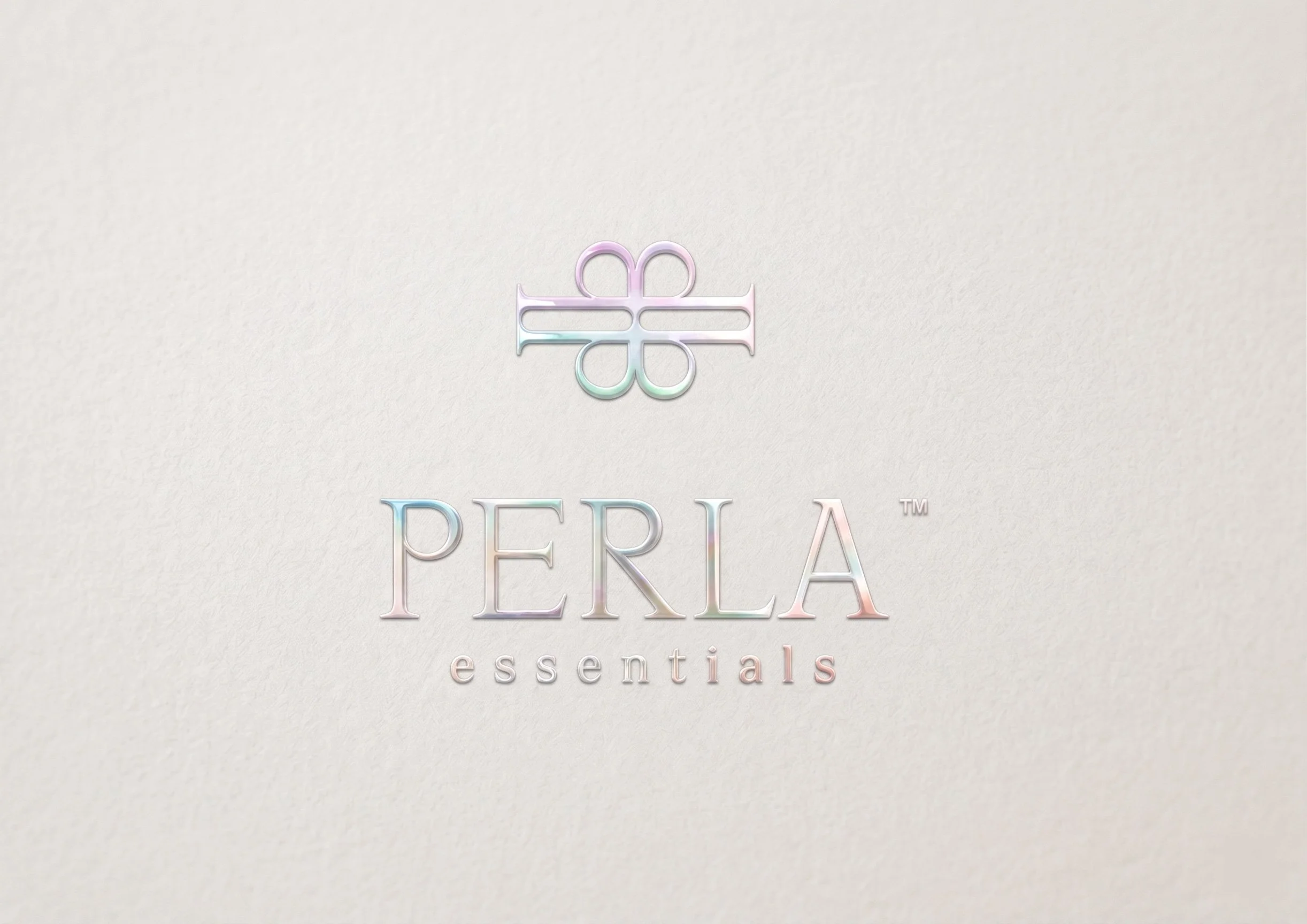 PERLA Essentials' logo is presented with holographic foil embossing on textured cardstock 