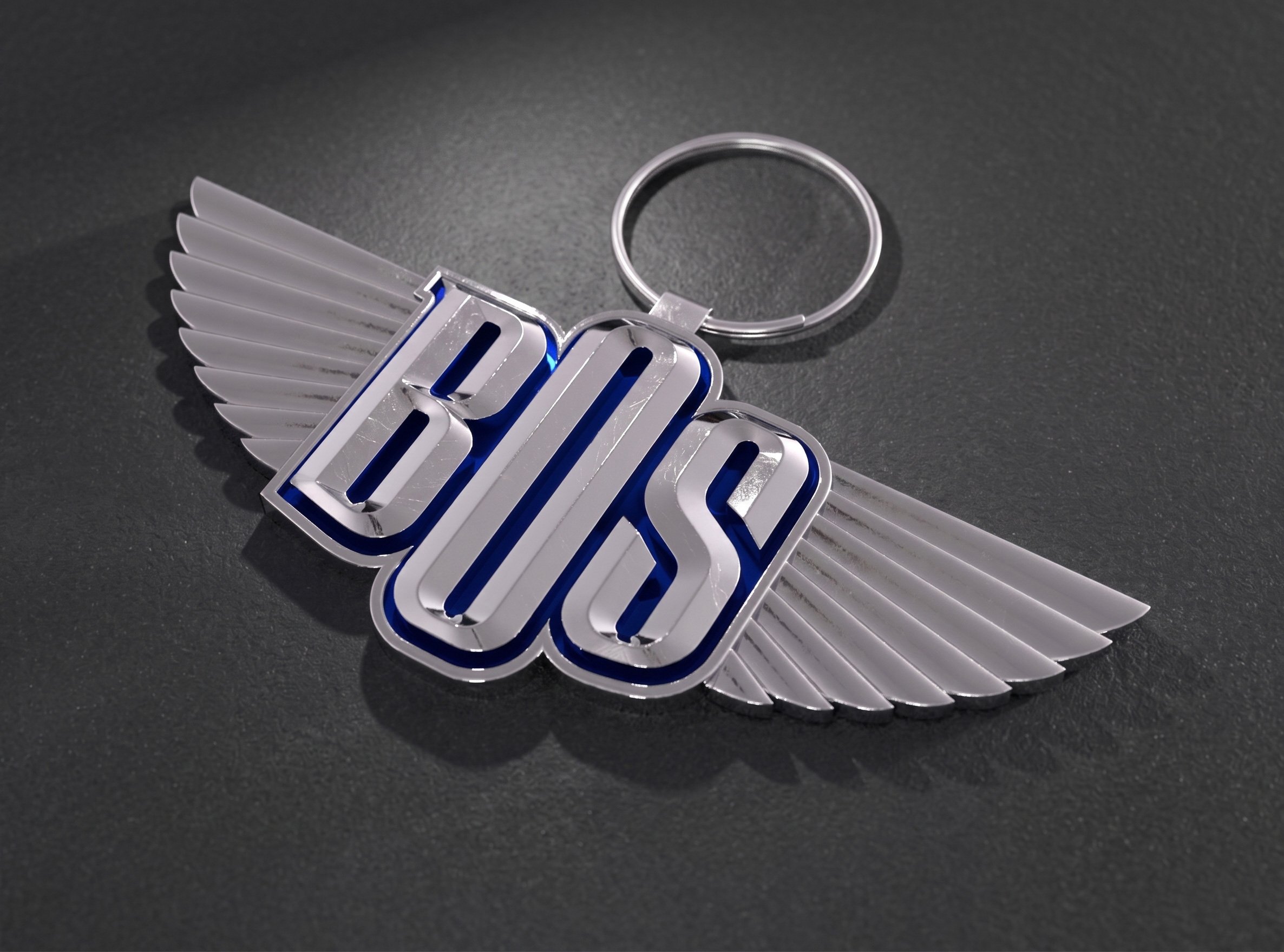 A high-quality metallic chrome Bengkel BOS winged logo keychain accessory displayed on a dark surface