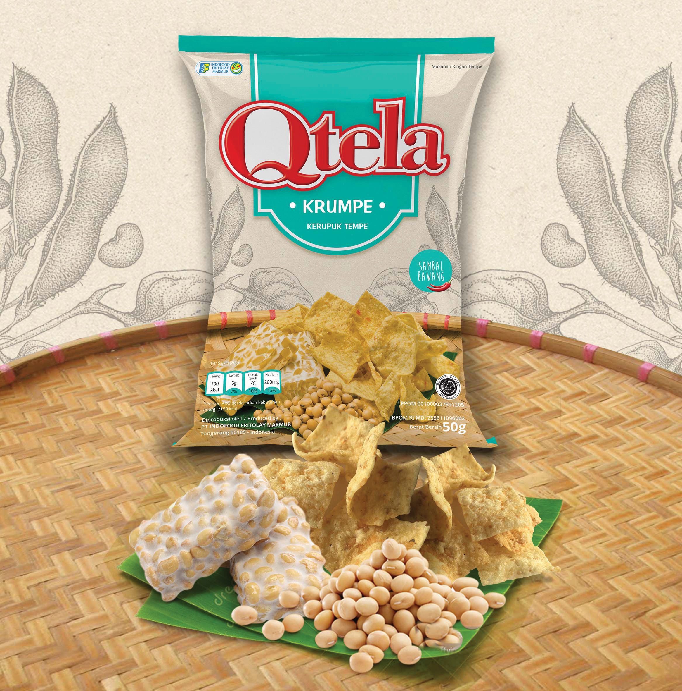 A bag of Qtela Keripik Tempe snack packaging displayed on a traditional woven bamboo mat with raw tempeh blocks and soybeans