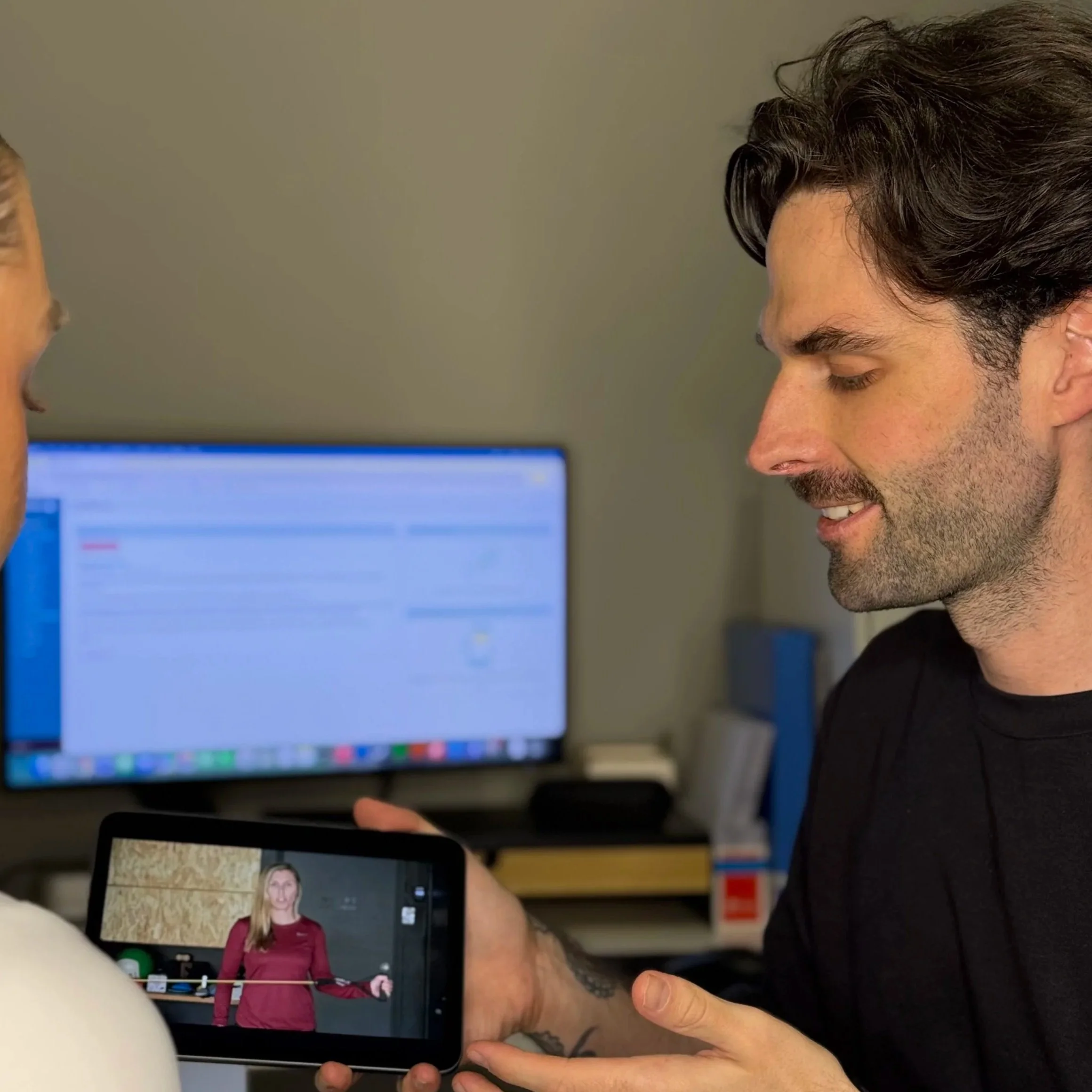 A clinician showing an exercise to a patient using an iPad.