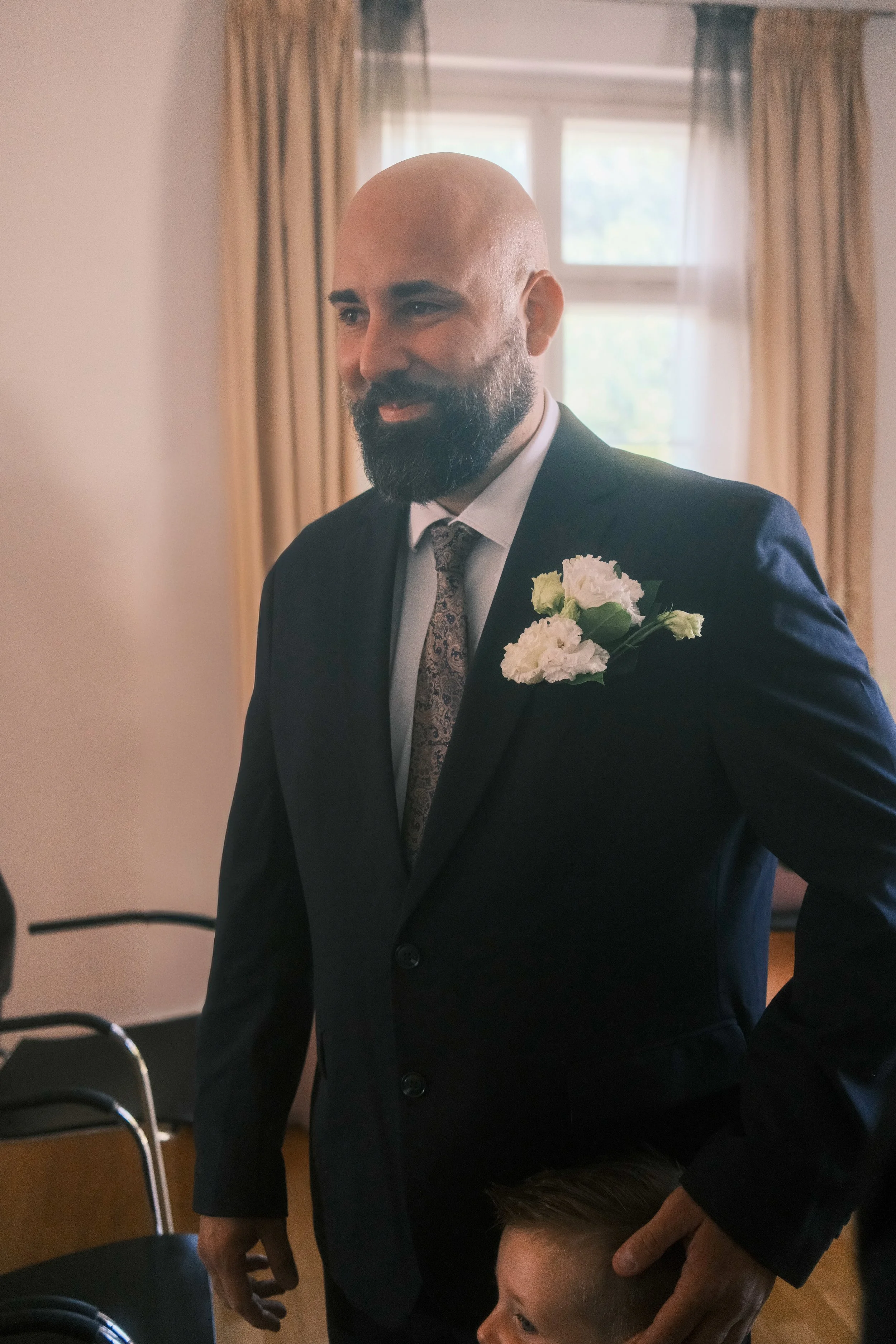 Lächelnder Bräutigam mit weißem Anstecker kurz vor der Trauung, Hochzeit in Leipzig