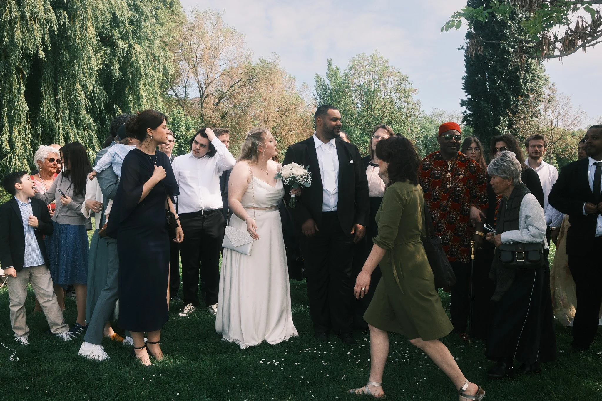 Brautpaar bei ihrer Hochzeit im Park in Leipzig, umgeben von Gästen