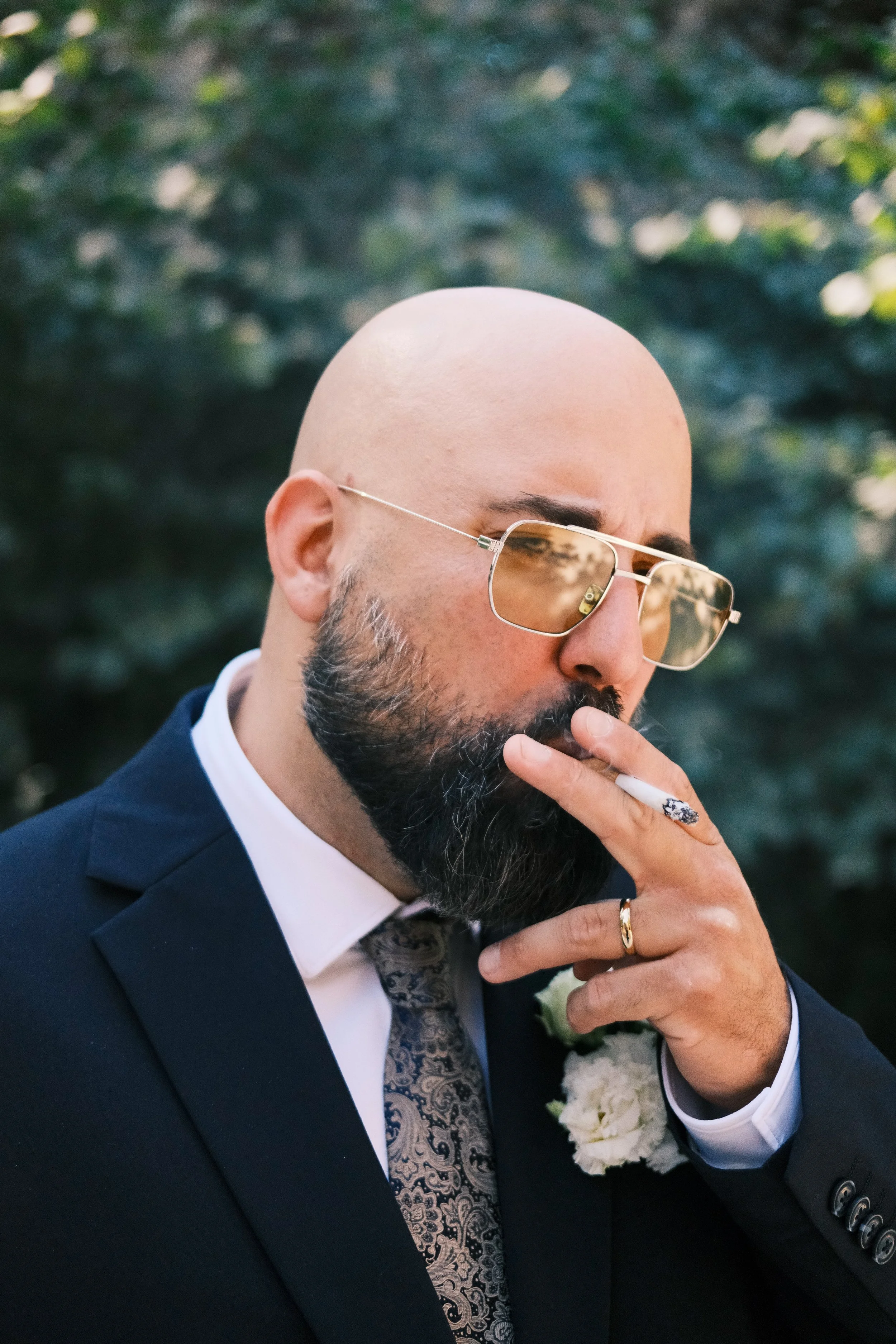 Bräutigam mit Sonnenbrille raucht eine Zigarette bei einer Hochzeit in Leipzig