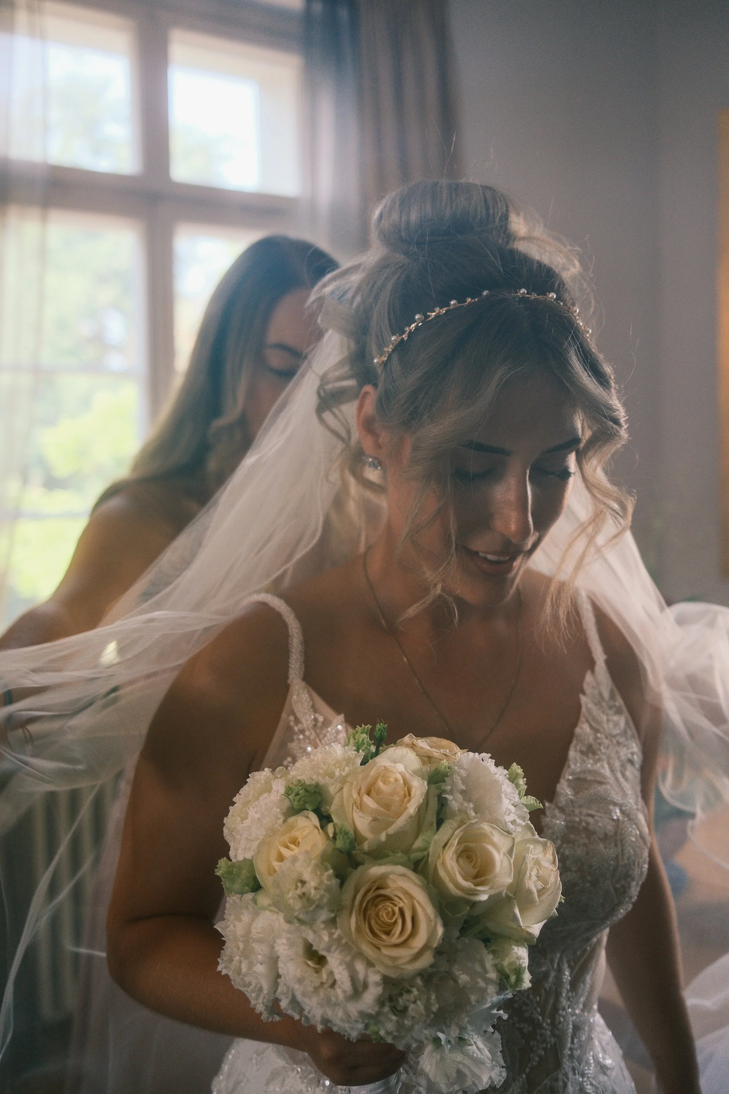Lächelnde Braut mit cremefarbenem Rosenstrauß beim Getting Ready, Hochzeit in Leipzig